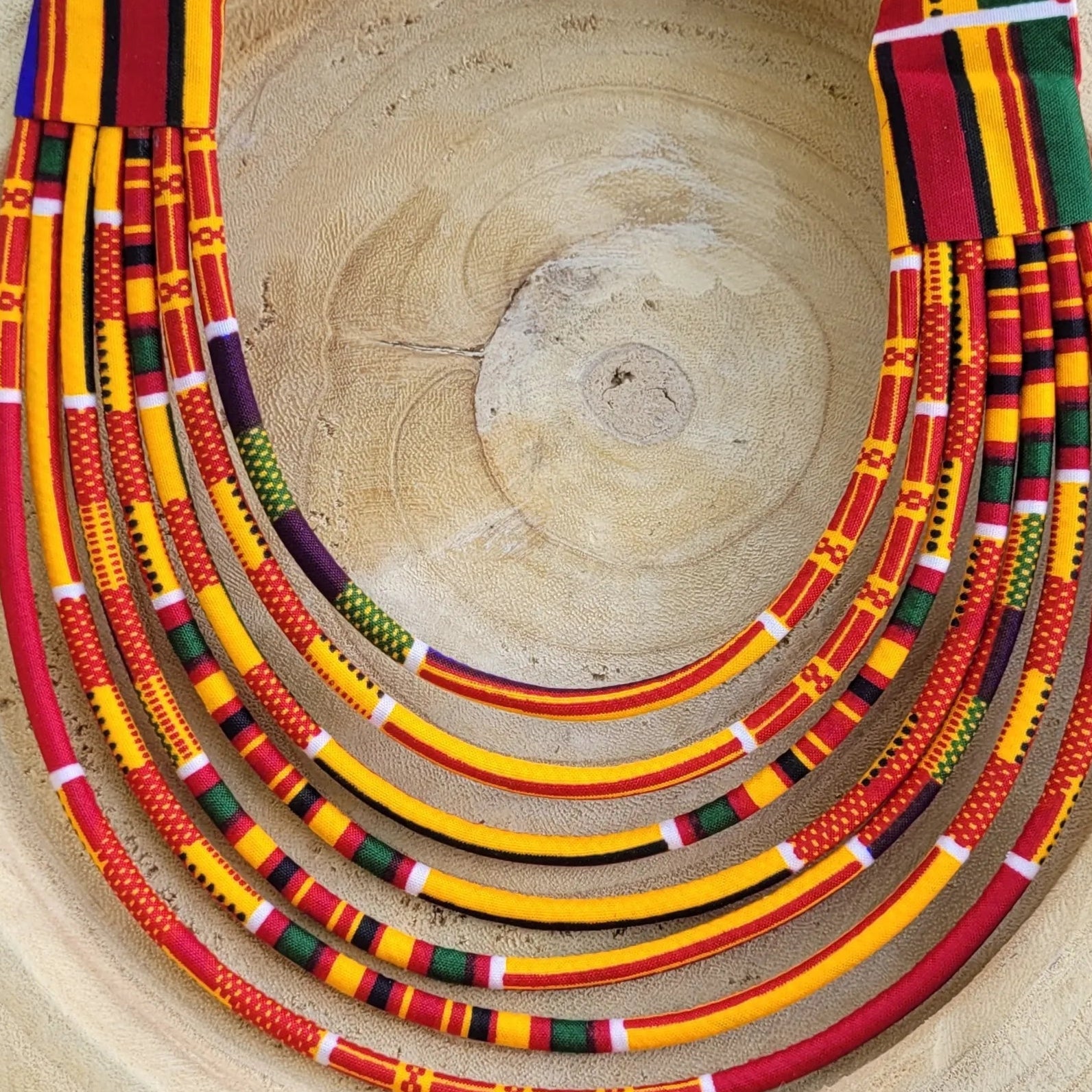 collier en tissu Fatou, un collier coloré composé de sept rangs de cordons recouverts de tissu wax