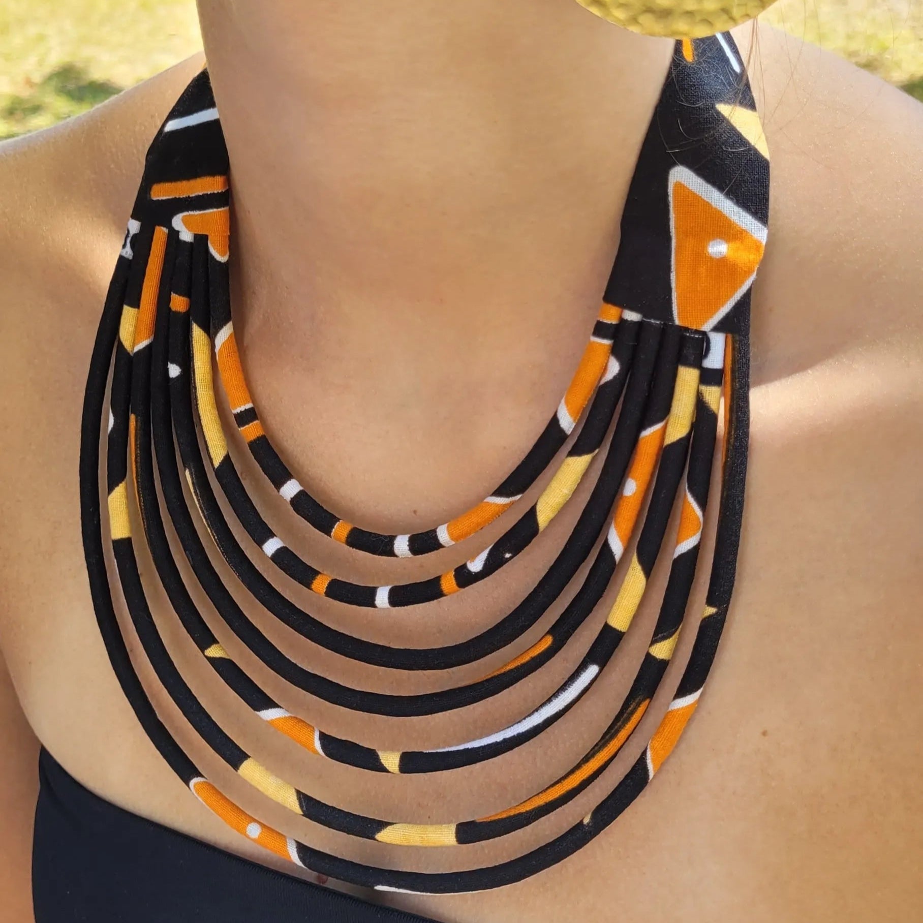 collier en tissu Fidèle, un collier coloré en wax noir et orangé