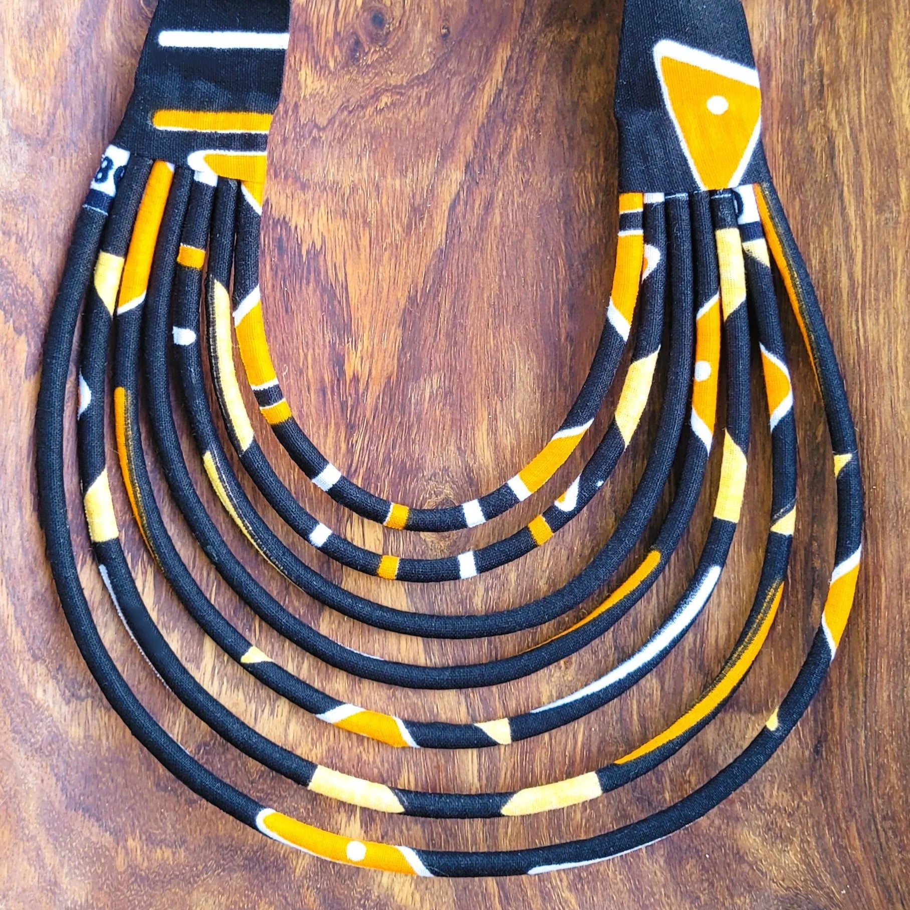 collier en tissu Fidèle, un collier coloré en pagne noir et orangé