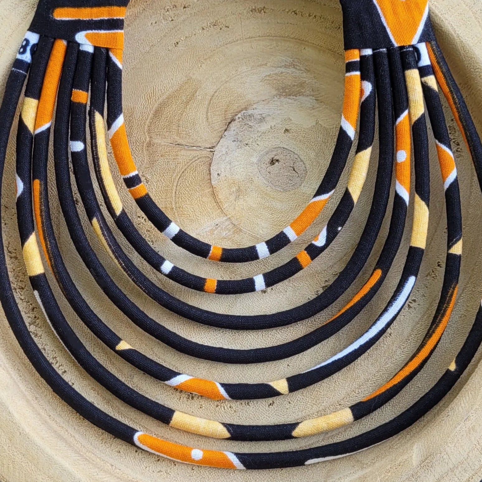 collier en tissu Fidèle, un collier coloré composé de sept rangs de cordons recouverts de tissu wax