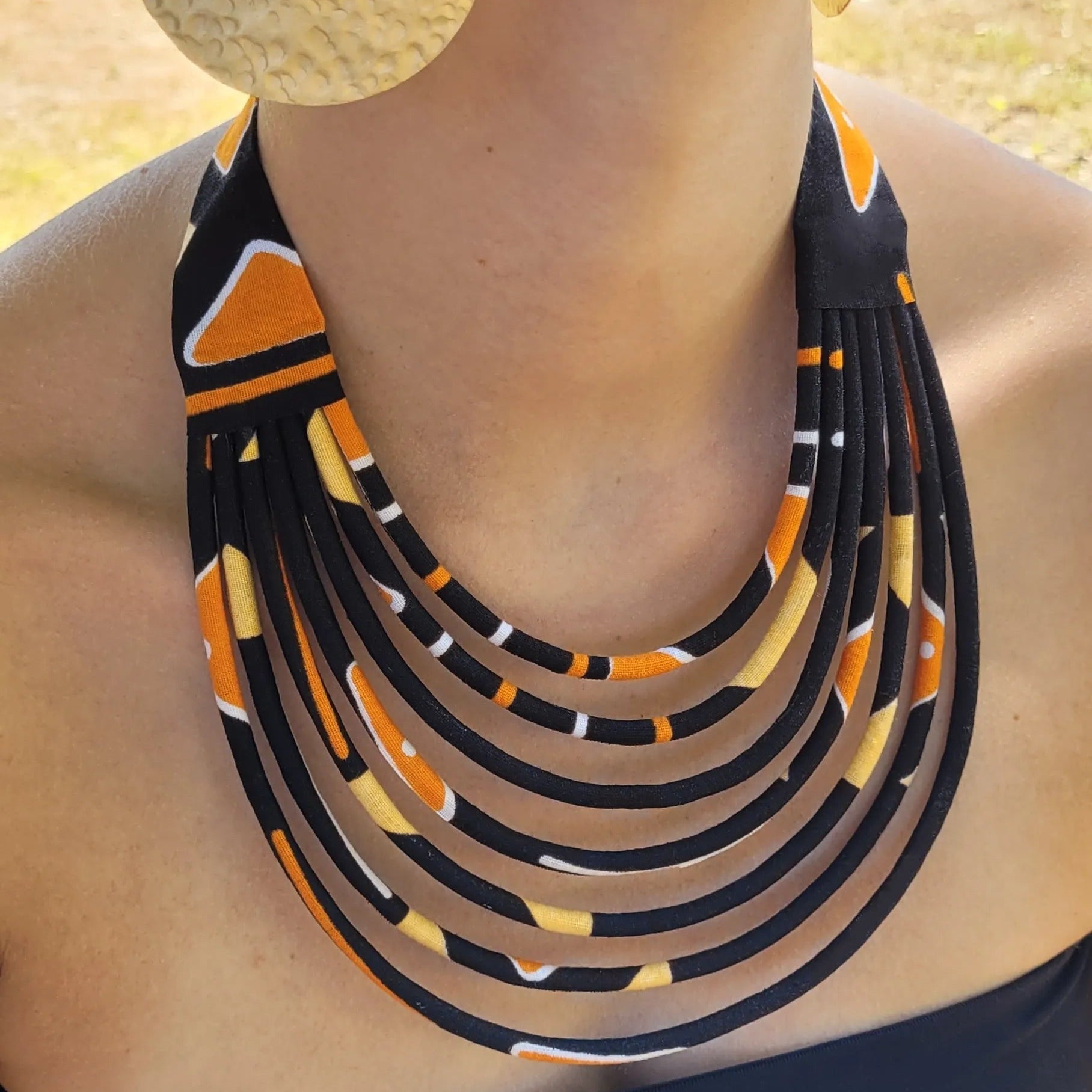 collier en tissu Fidèle, un collier ethnique chic composé de sept rangs de cordons recouverts de tissu wax