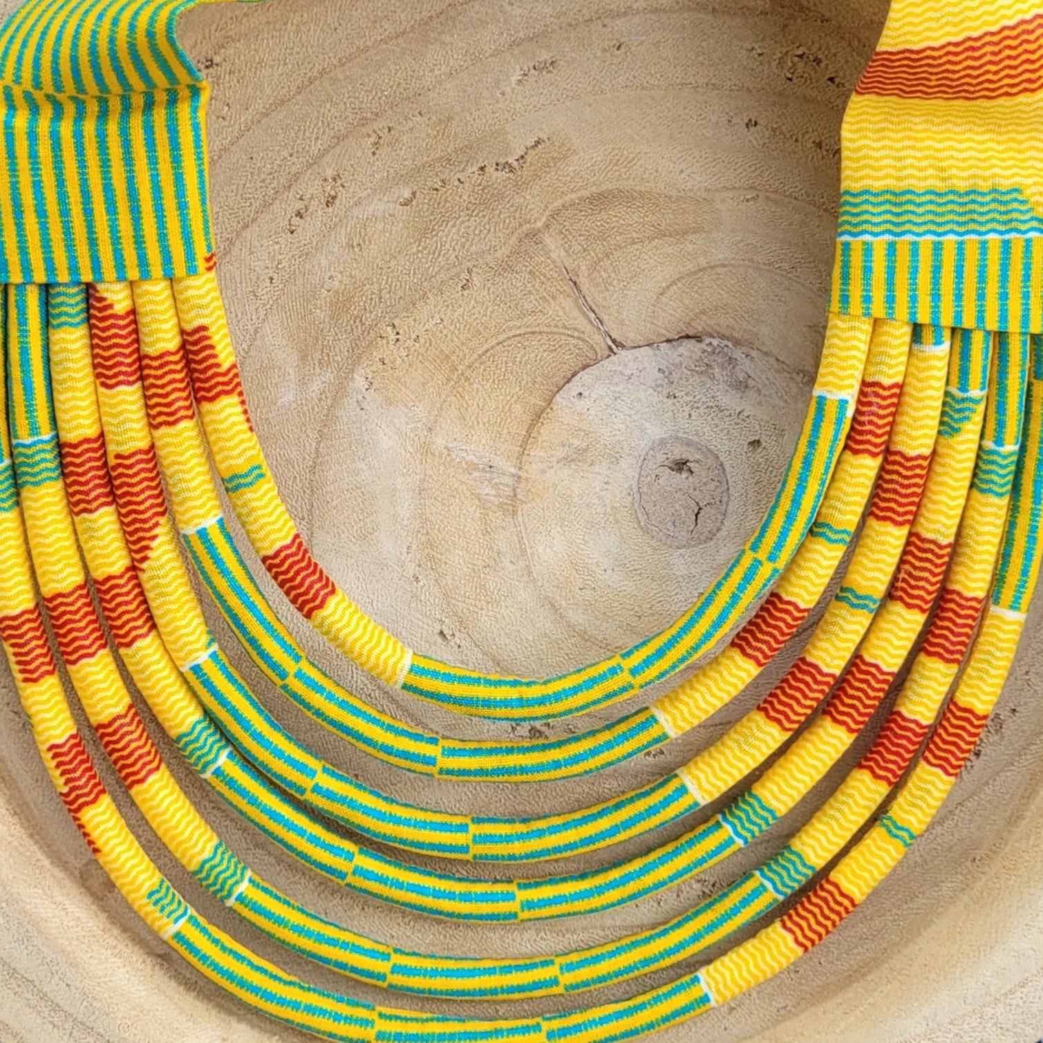 collier en tissu Malia, un collier coloré composé de sept rangs de cordons recouverts de tissu wax