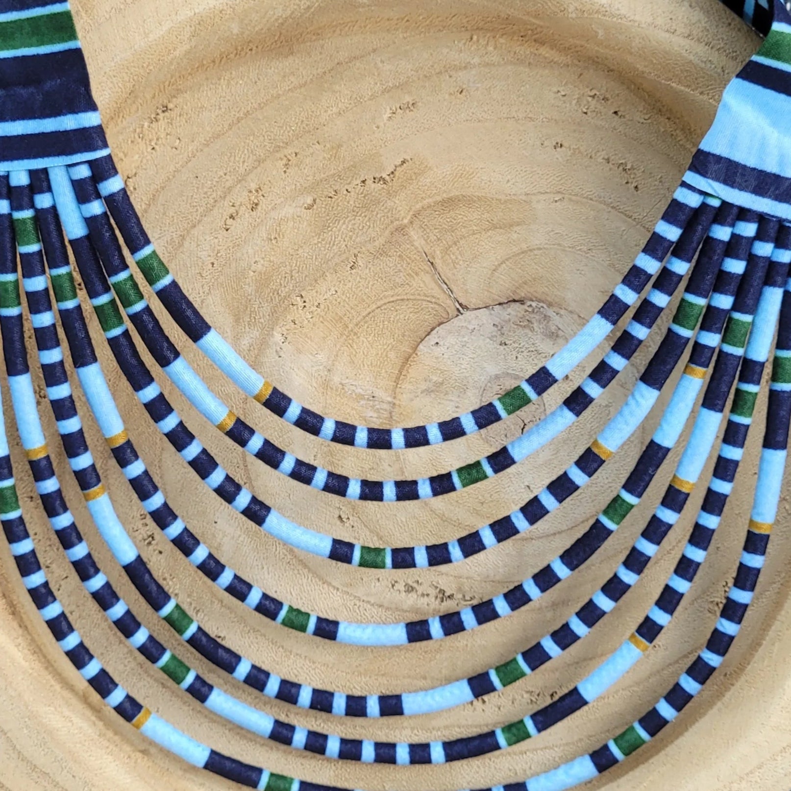collier en tissu Mariama, un collier coloré composé de sept rangs de cordons recouverts de tissu wax