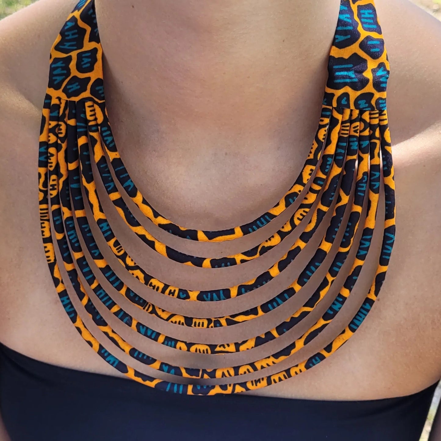 collier en tissu Nabintou, un collier coloré en wax orange, noir et bleu canard