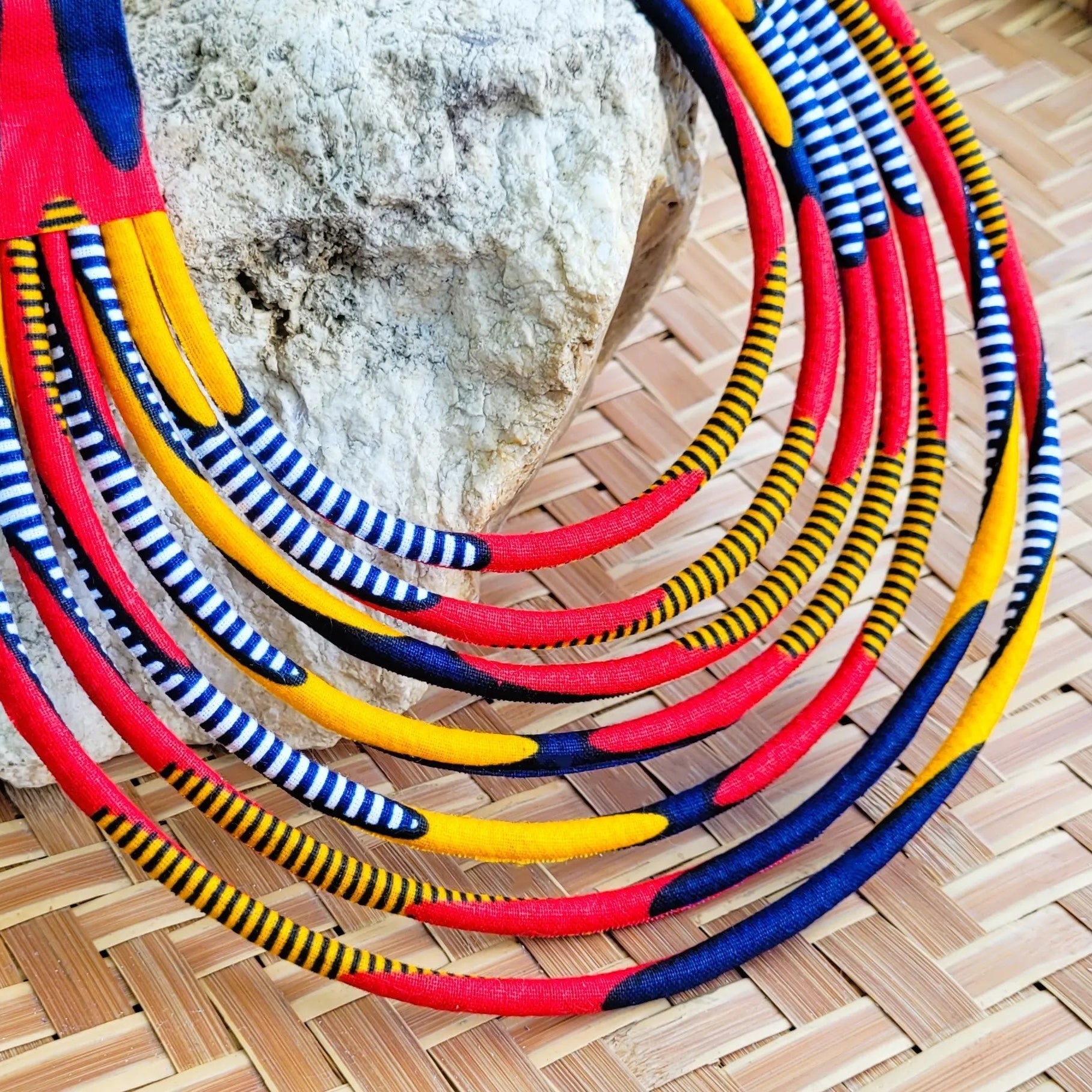 collier en tissu Nabou, un bijou africain traditionnel en wax rouge, orange, marine et noir