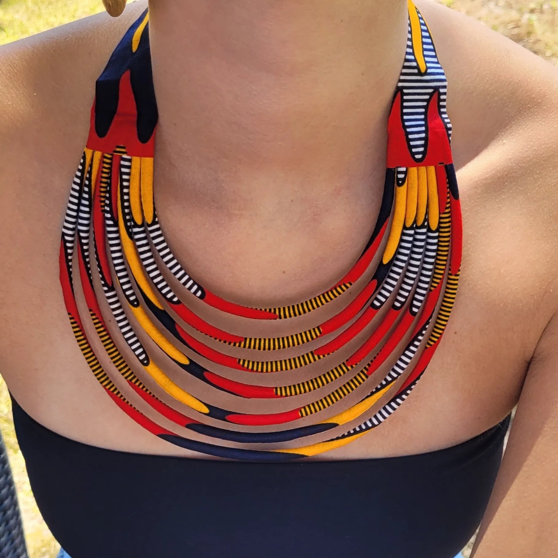 collier en tissu Nabou, un collier coloré en wax rouge, orange, marine et noir