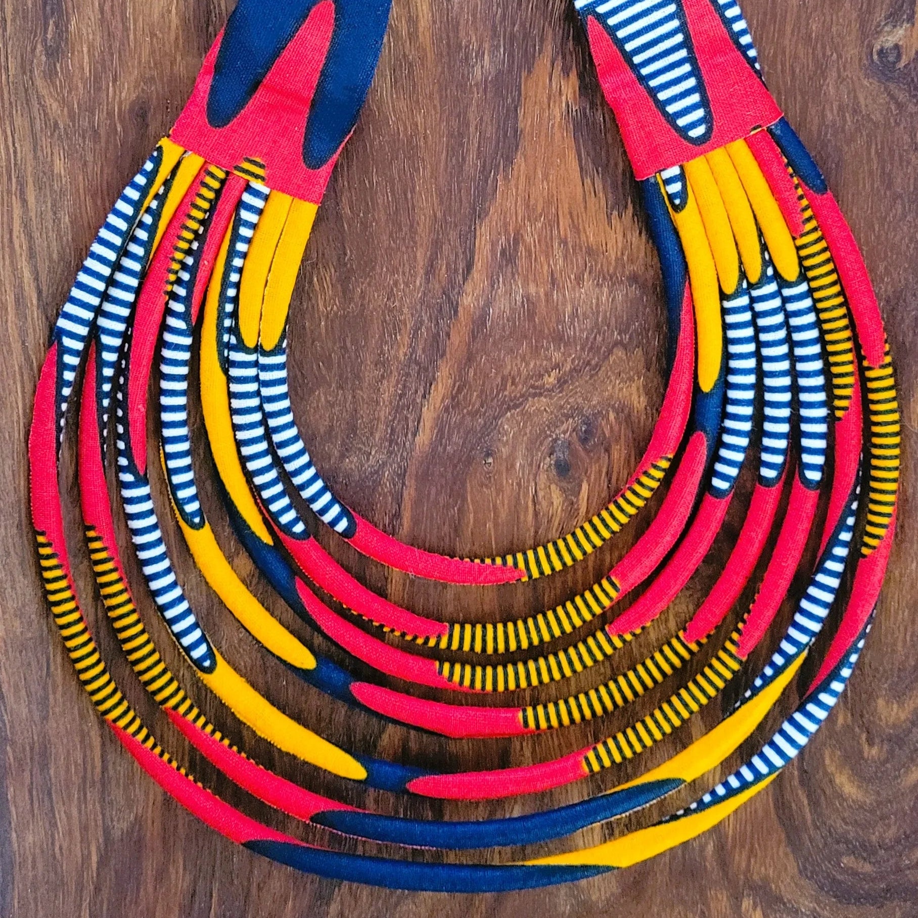 collier en tissu Nabou, un collier coloré en pagne rouge, orange, marine et noir