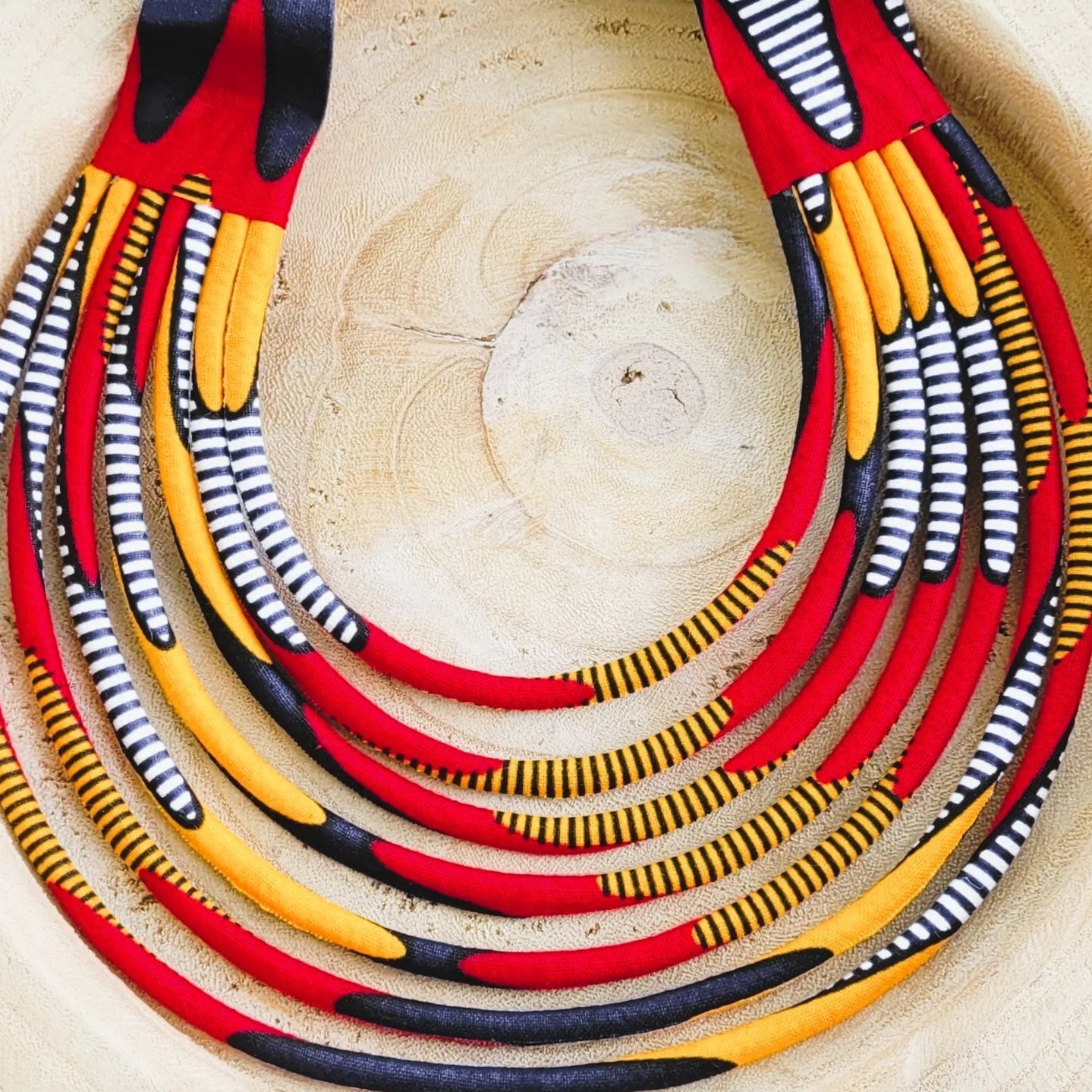 collier en tissu Nabou, un collier coloré composé de sept rangs de cordons recouverts de tissu wax