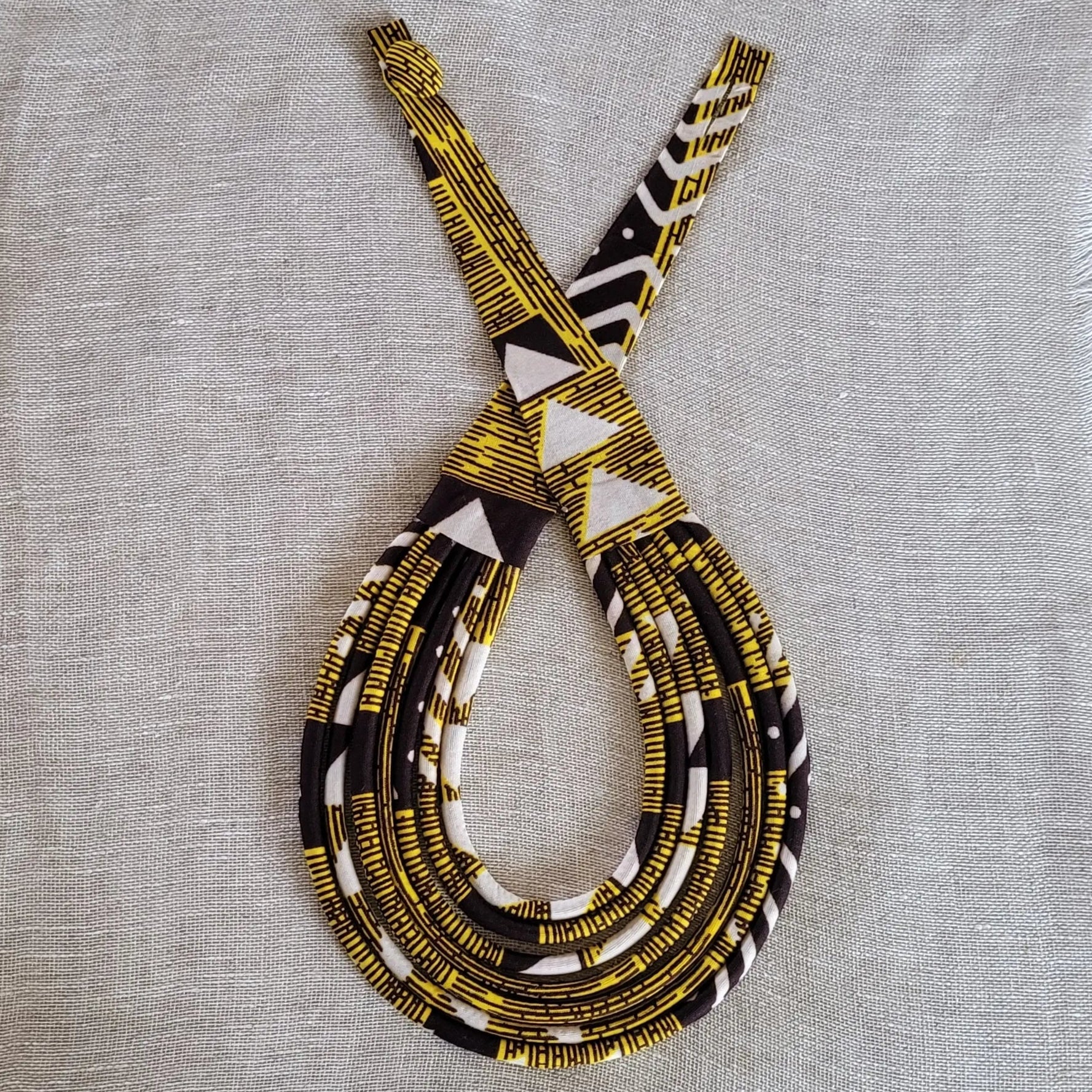 collier en tissu Nafi, un bijou africain traditionnel en pagne jaune, marron et crème