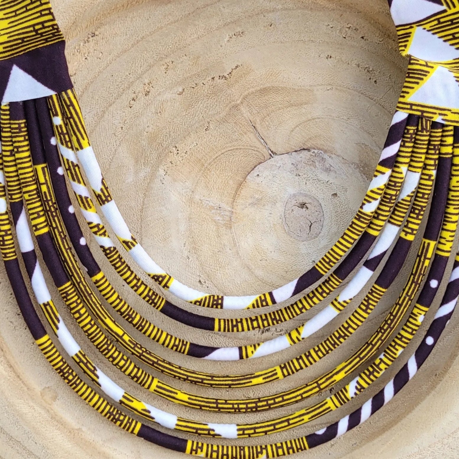 collier en tissu Nafi, un collier coloré composé de sept rangs de cordons recouverts de tissu wax