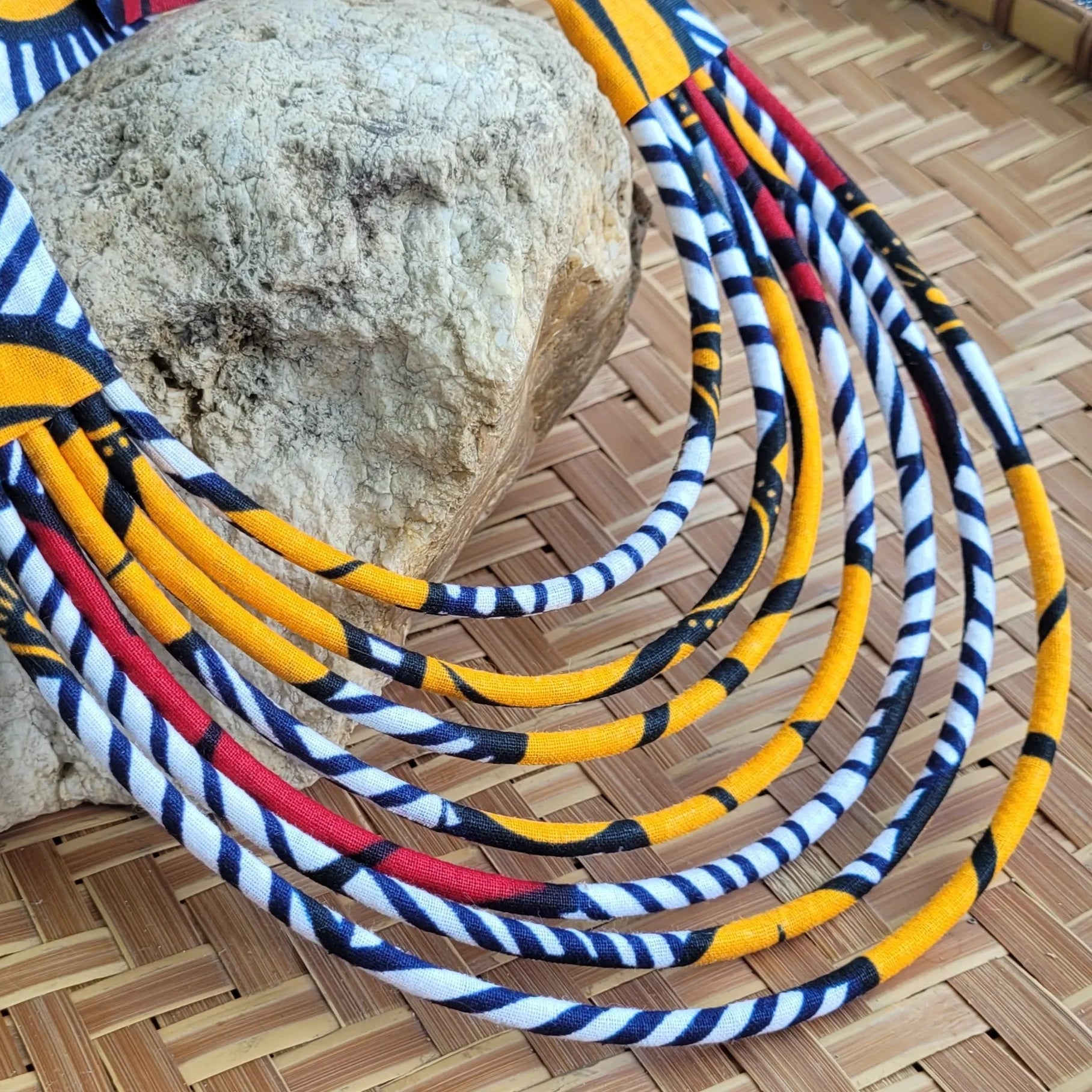 collier en tissu Ndidé, un bijou africain traditionnel en wax orange et blanc