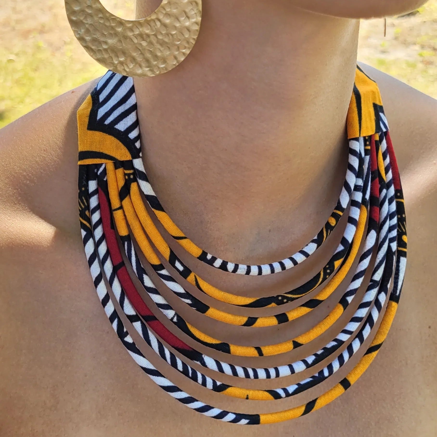 collier en tissu Ndidé, un collier ethnique chic composé de sept rangs de cordons recouverts de tissu wax