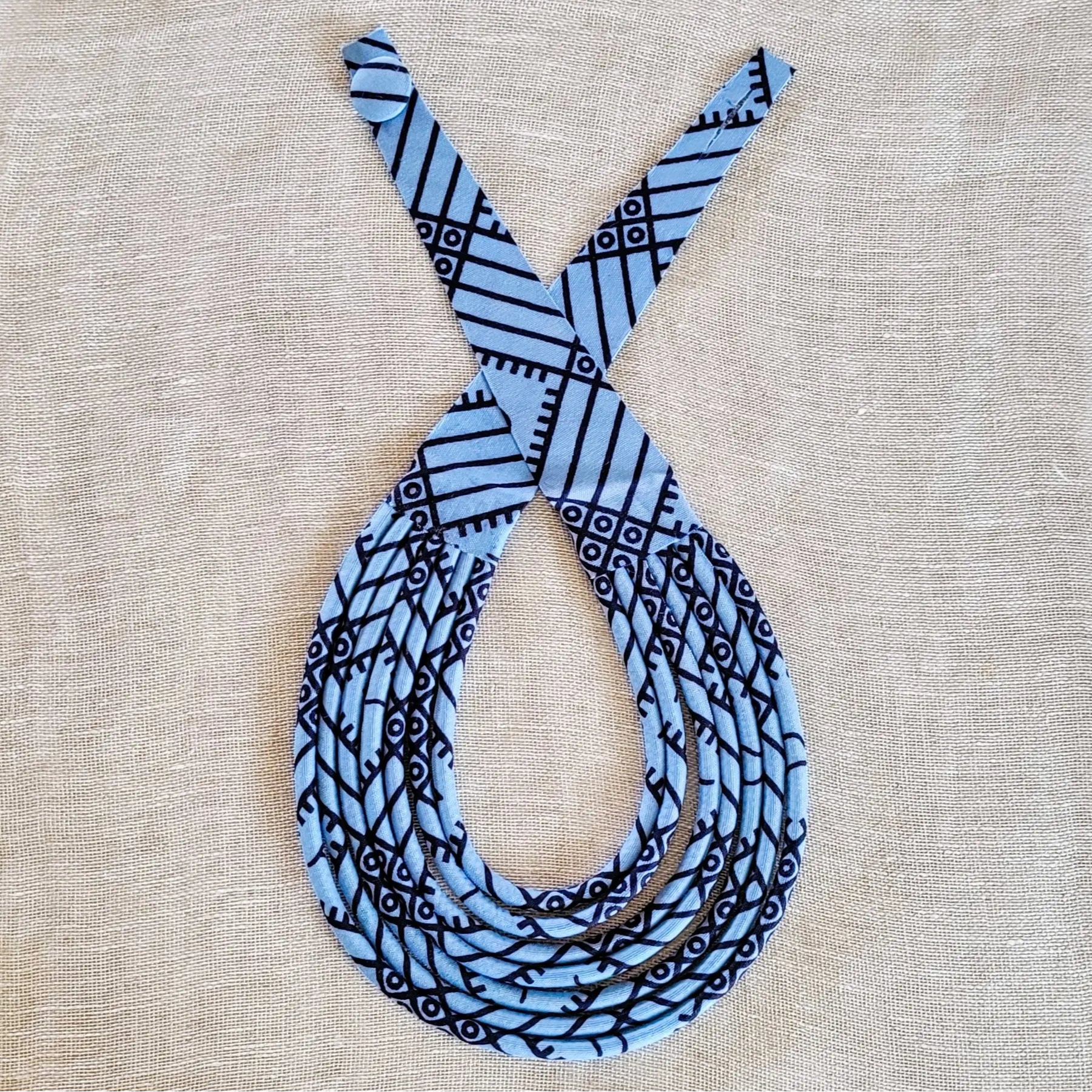 collier en tissu Ngoné, un bijou africain traditionnel en pagne bleu gris et noir