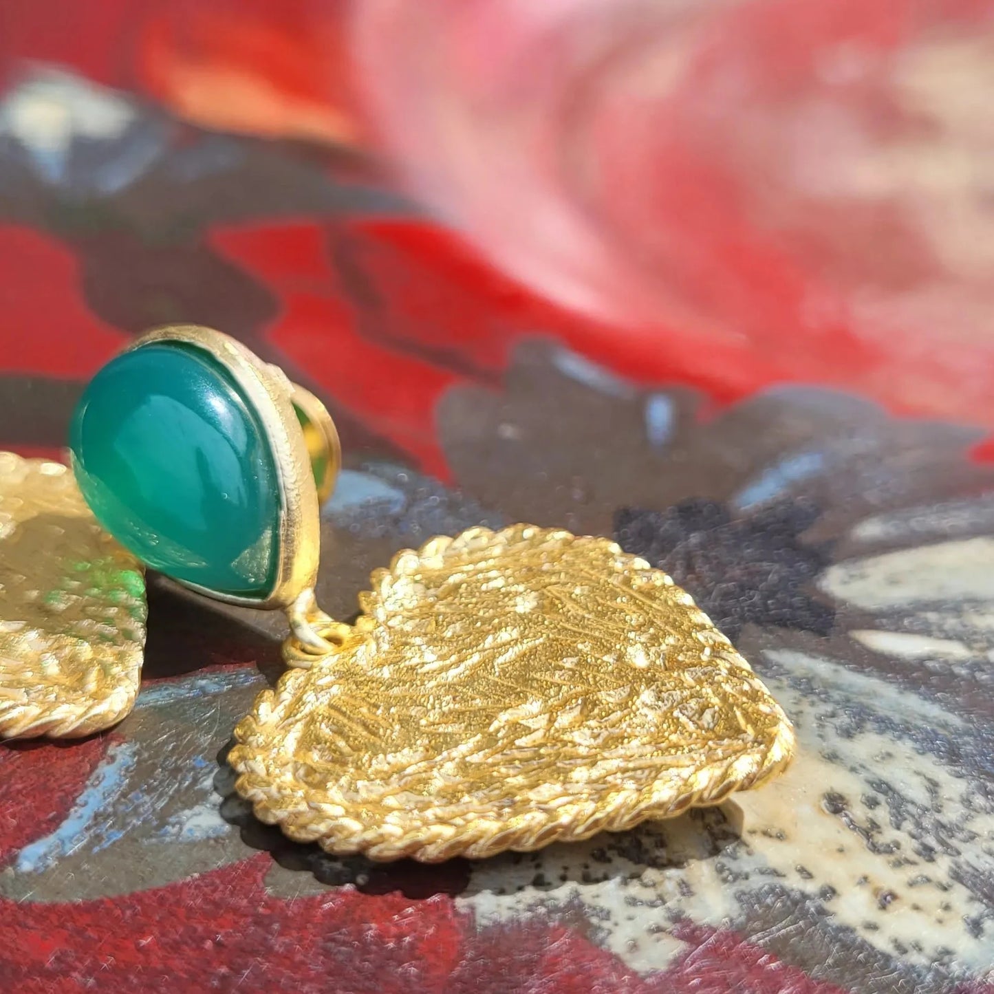 Cupidon avec pierre d’onyx vert de Niiki Paris, des boucles d’oreilles pendantes avec un cœur pour célébrer l’amour