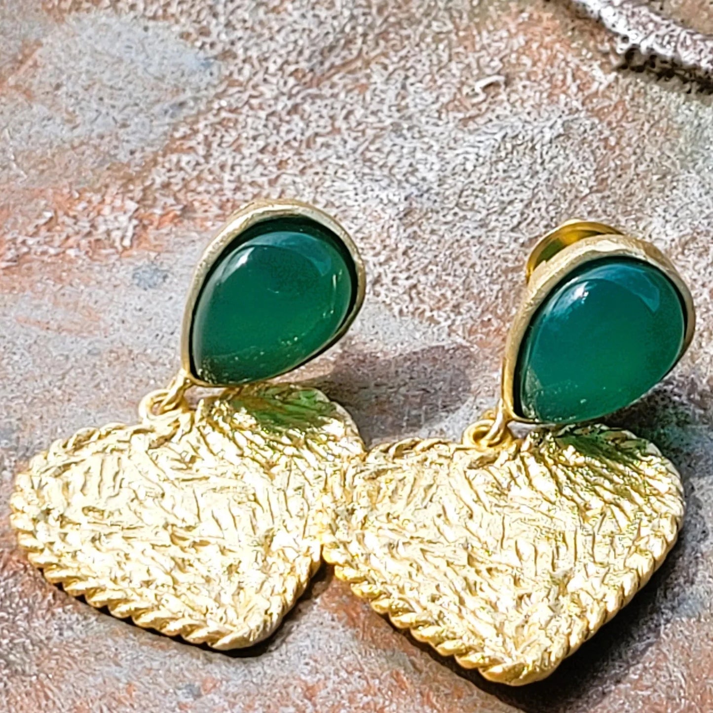 Cupidon avec pierre d’onyx vert de Niiki Paris, des boucles d’oreilles pendantes avec un cœur, une création romantique