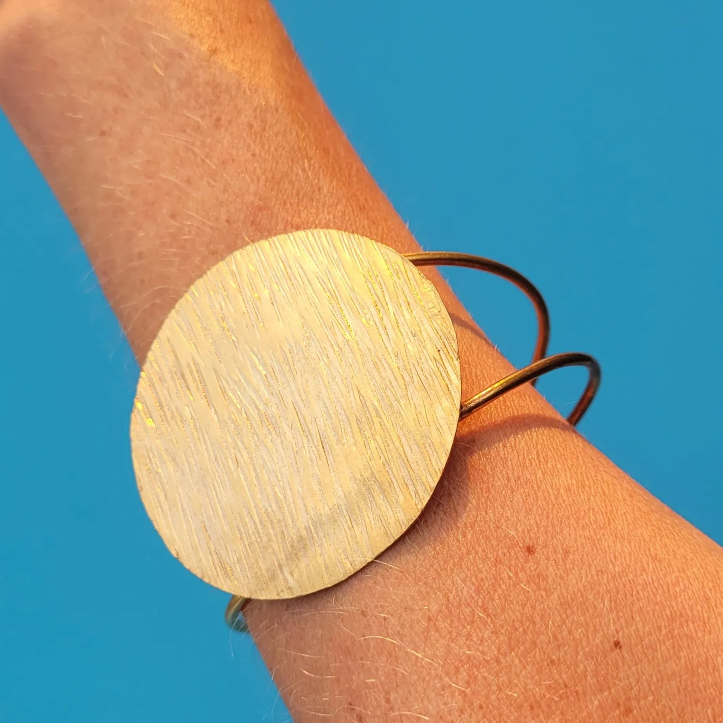 bracelet en bronze Lunja, un bijou africain orné d’un grand disque solaire