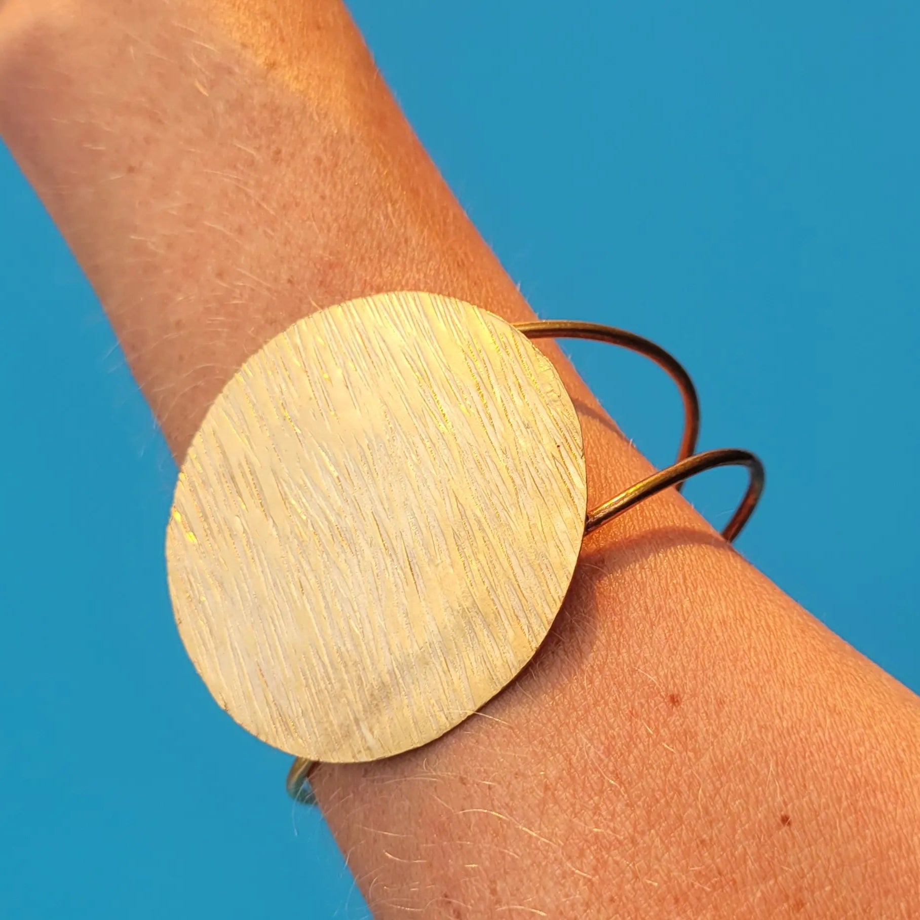 bracelet en bronze Lunja, un bijou africain orné d’un grand disque solaire