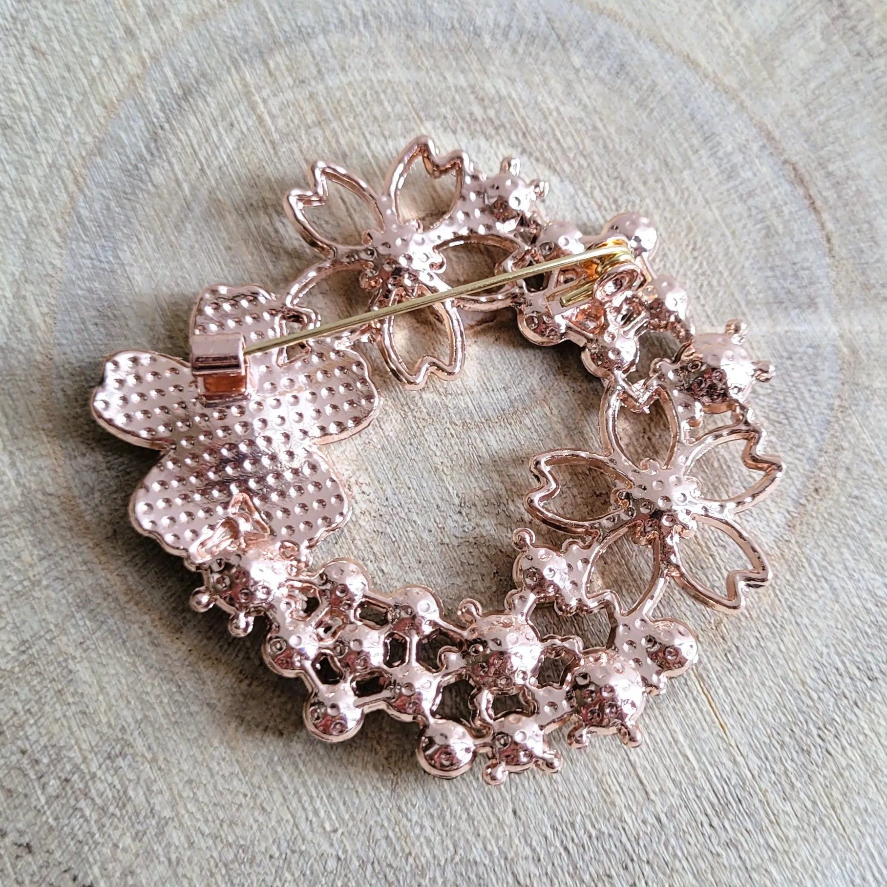 une broche dorée Flore en couronne de strass et fleurs pour sublimer un petit haut
