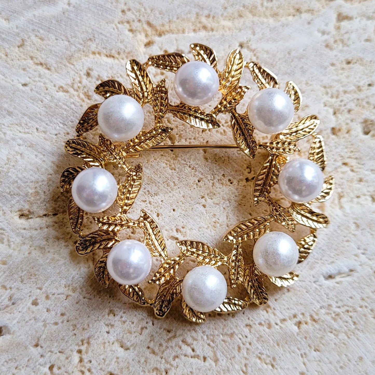 broche dorée Lauréa, un bijou moderne en forme de couronne de feuilles de laurier et perles nacrées