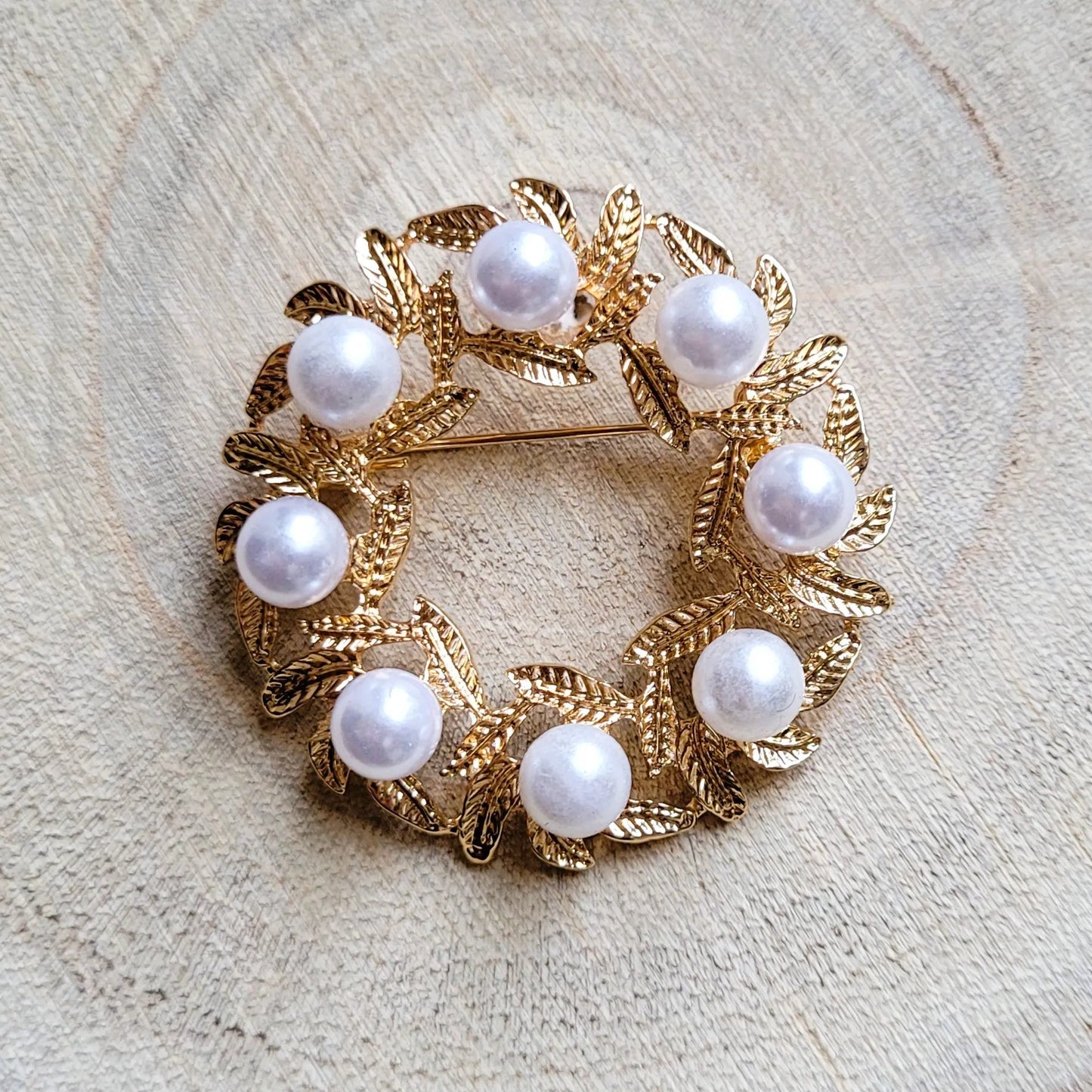 une broche dorée Lauréa de luxe en couronne de feuilles de laurier et perles nacrées