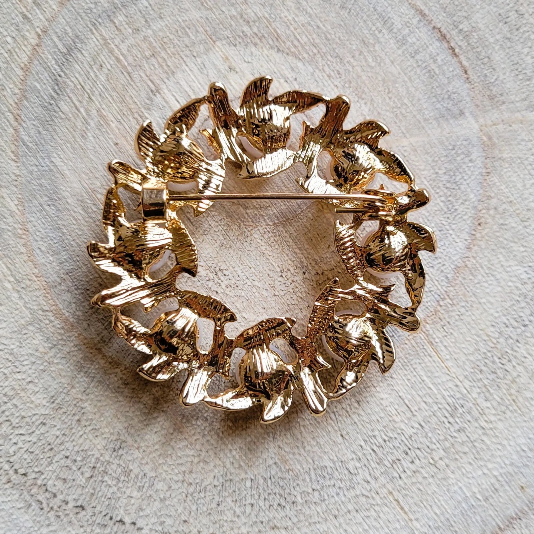 une broche dorée Lauréa en couronne de feuilles de laurier et perles nacrées pour sublimer un petit haut