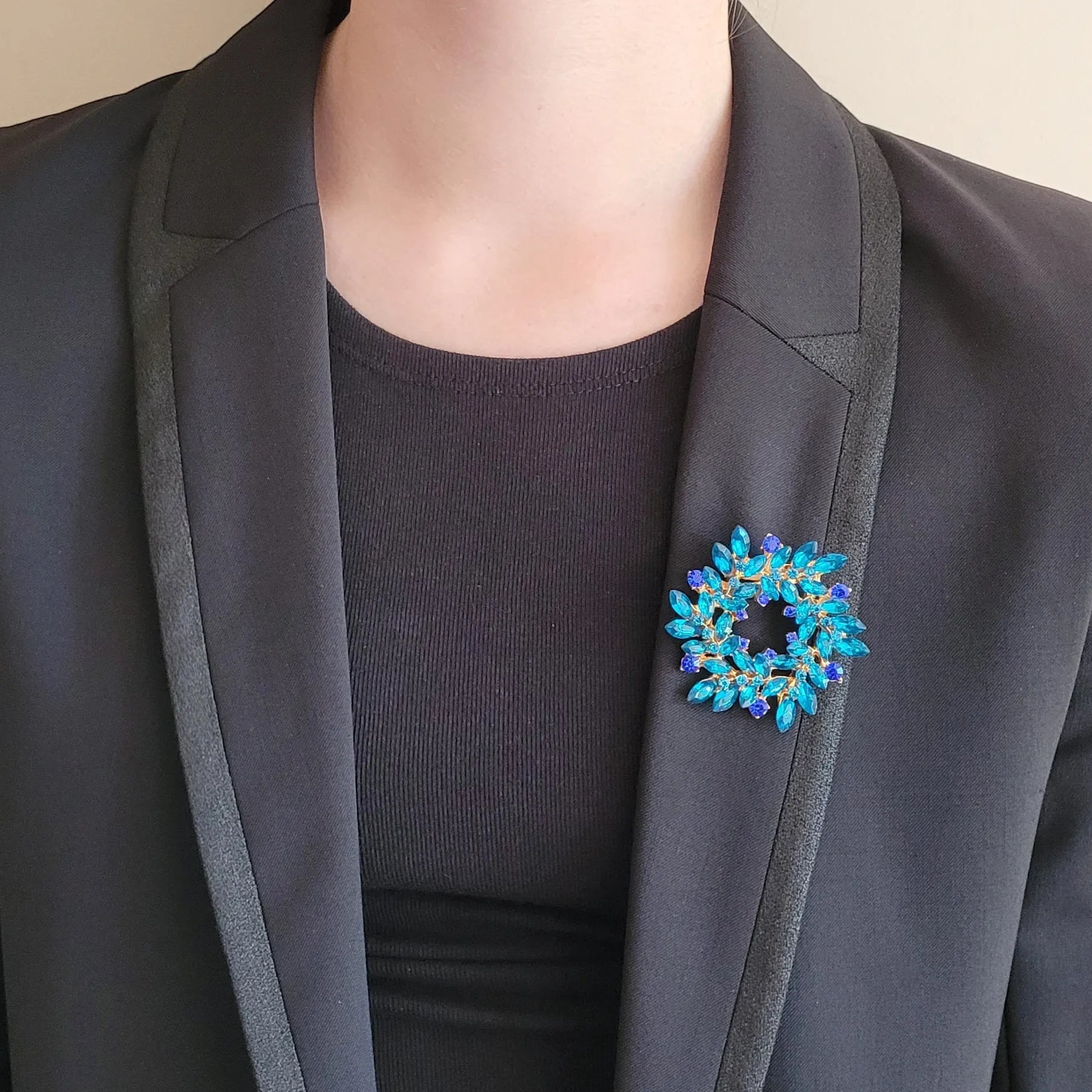 une broche dorée Merveilleuse de luxe en couronne de strass bleue