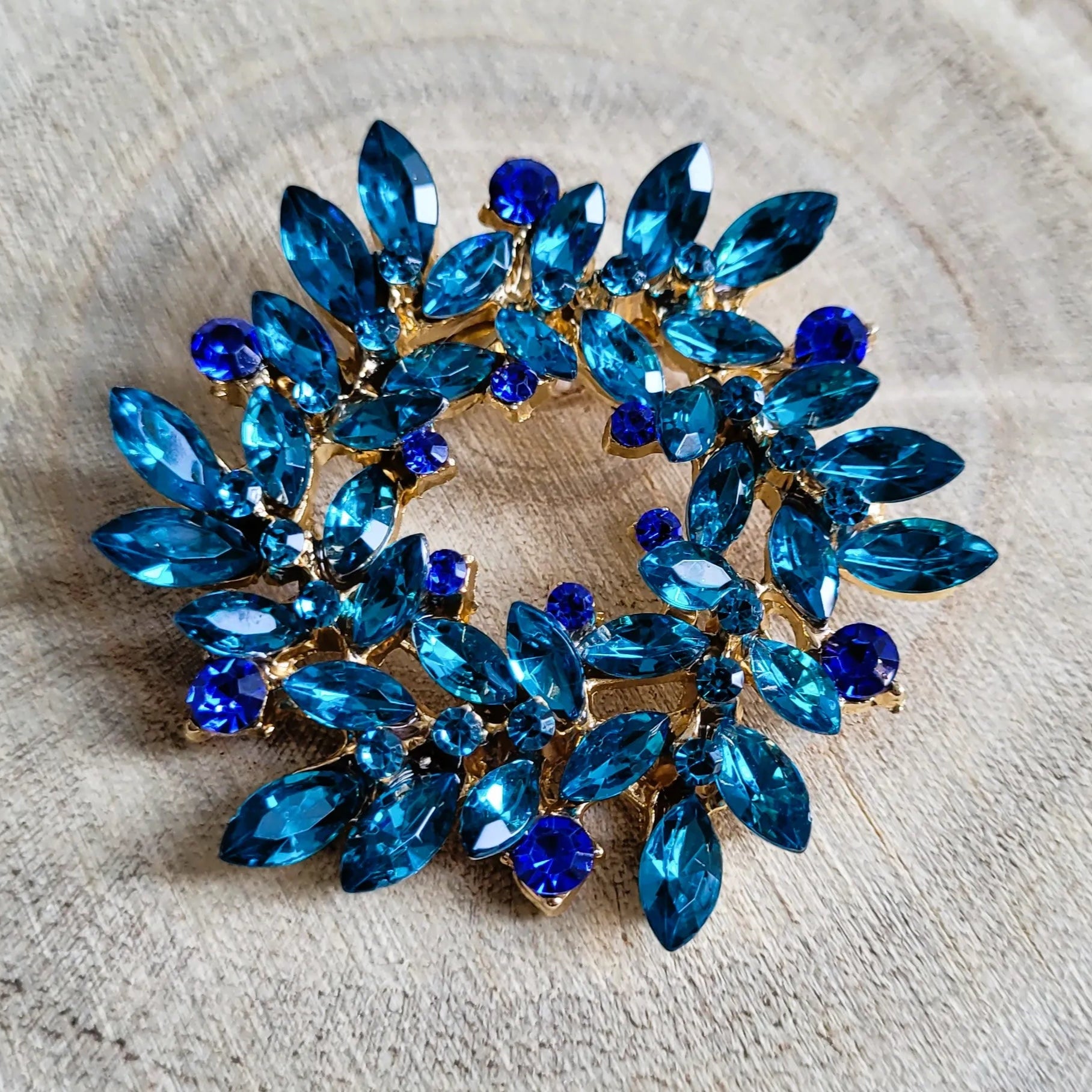 une broche dorée Merveilleuse en couronne de strass bleue pour sublimer un petit haut