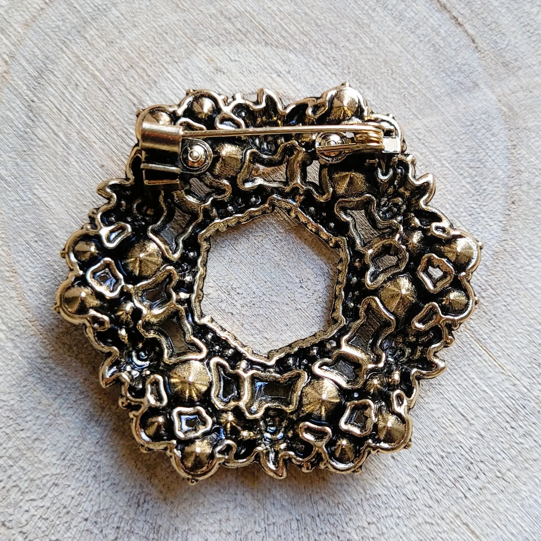 une broche dorée Souveraine en couronne de roses et de feuillage en strass pour sublimer un petit haut