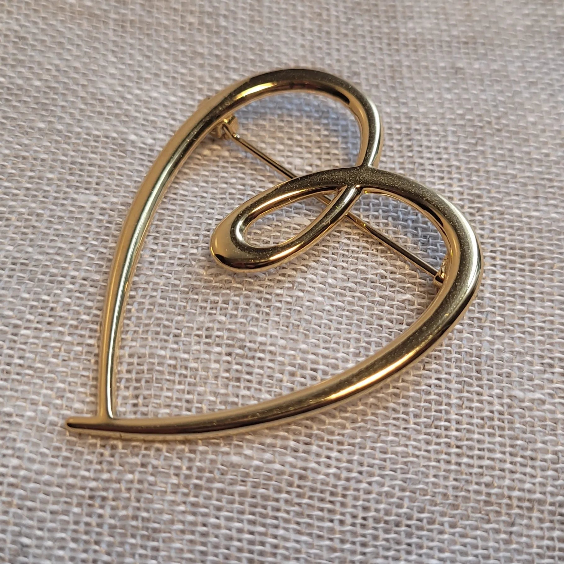 une broche dorée Tendress de luxe d’un cœur à la ligne épurée
