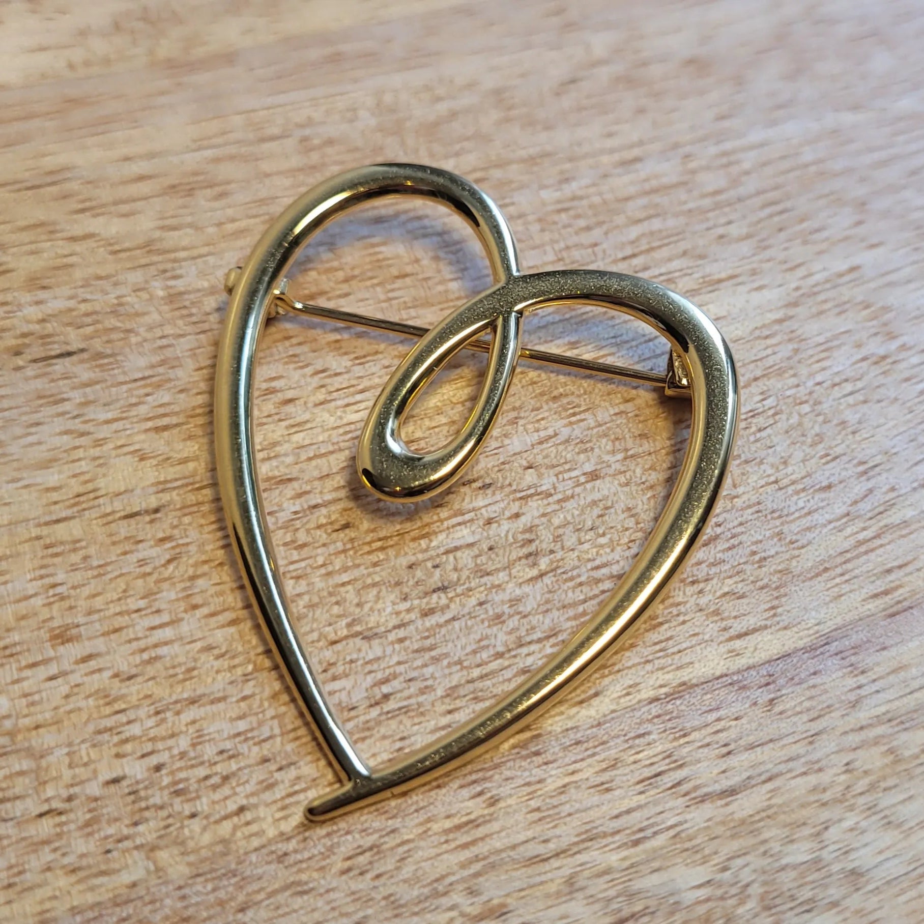 une broche dorée Tendress d’un cœur à la ligne épurée pour sublimer un petit haut