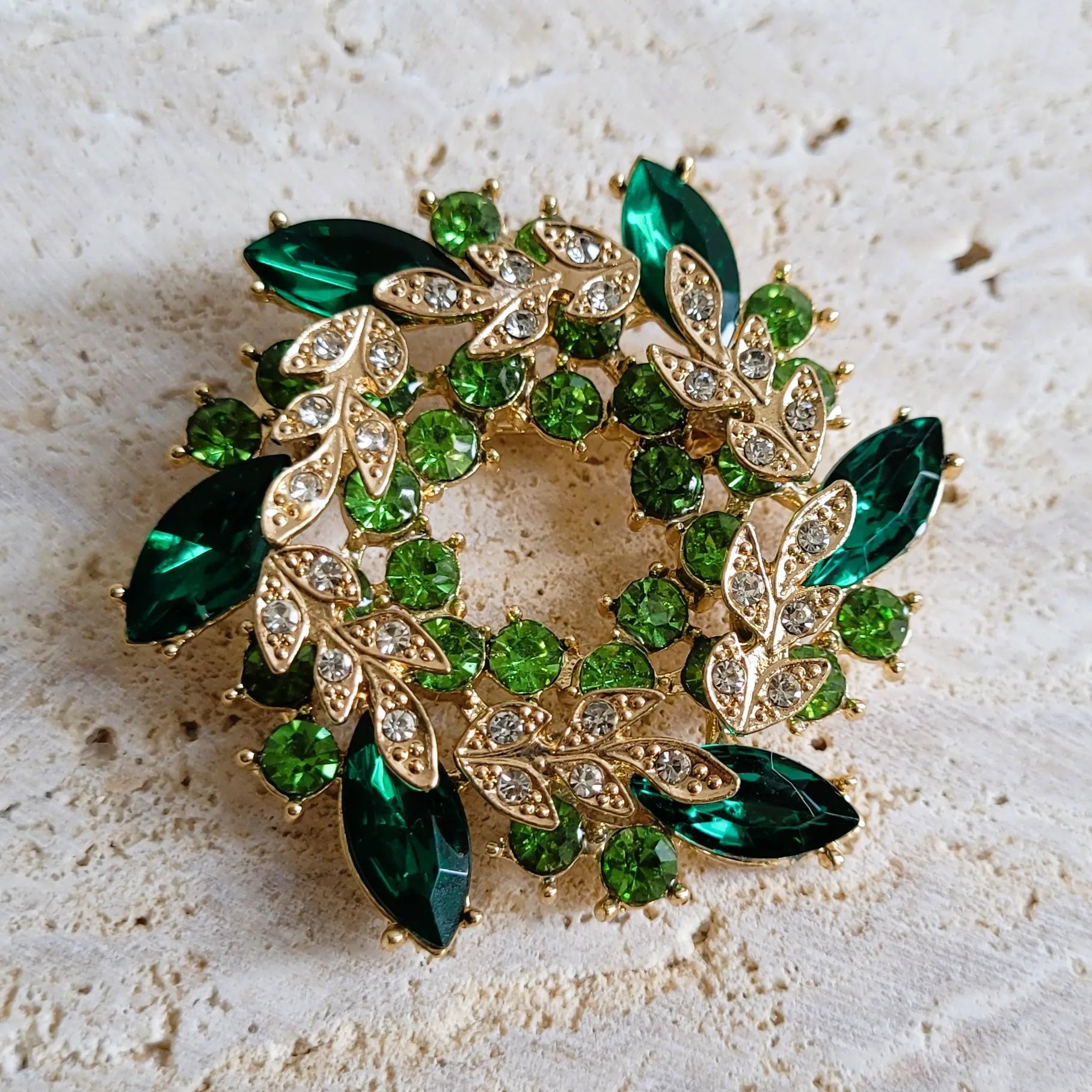 broche dorée Végétalia, un bijou moderne en forme de couronne de feuilles vert émeraude