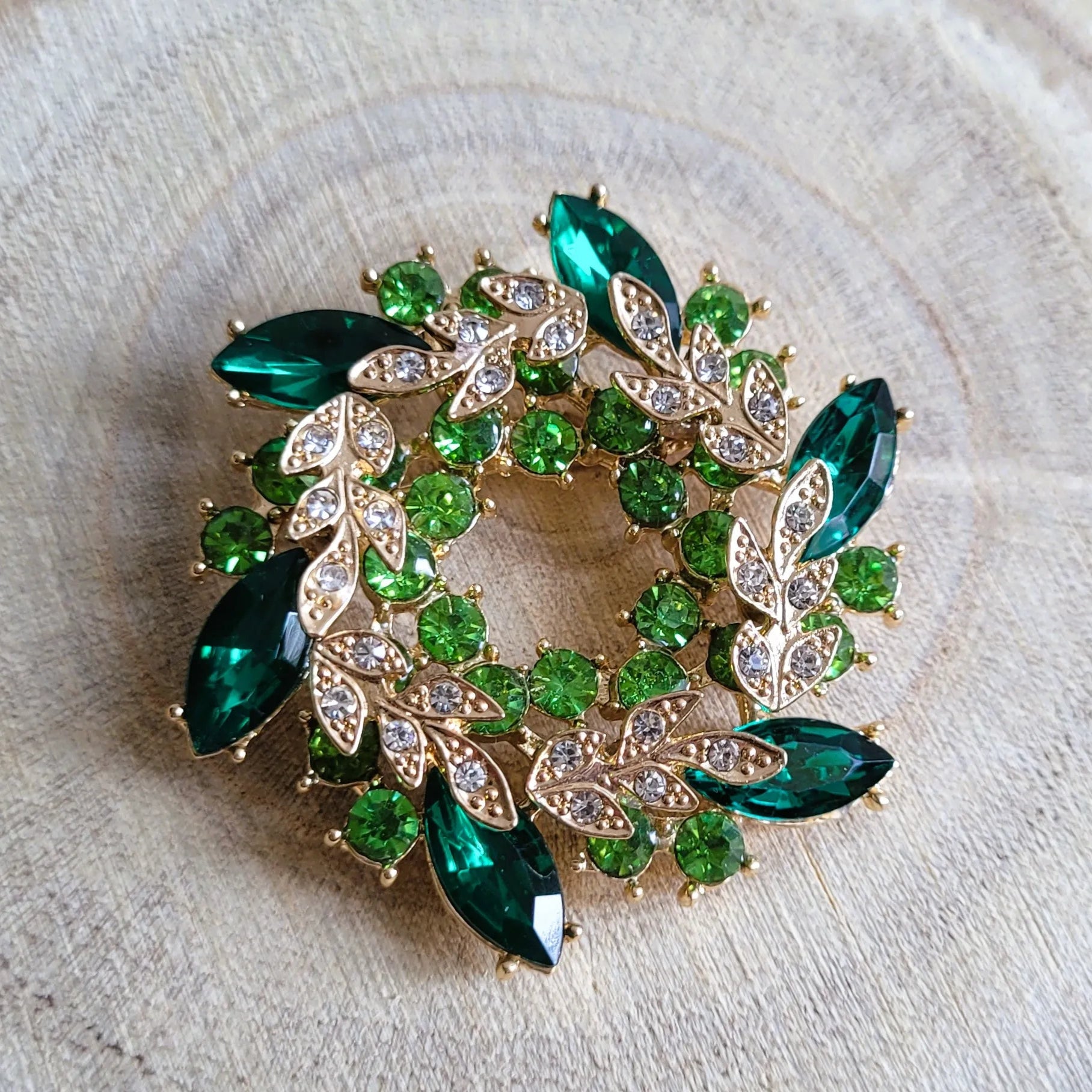 une broche dorée Végétalia de luxe en couronne de feuilles vert émeraude