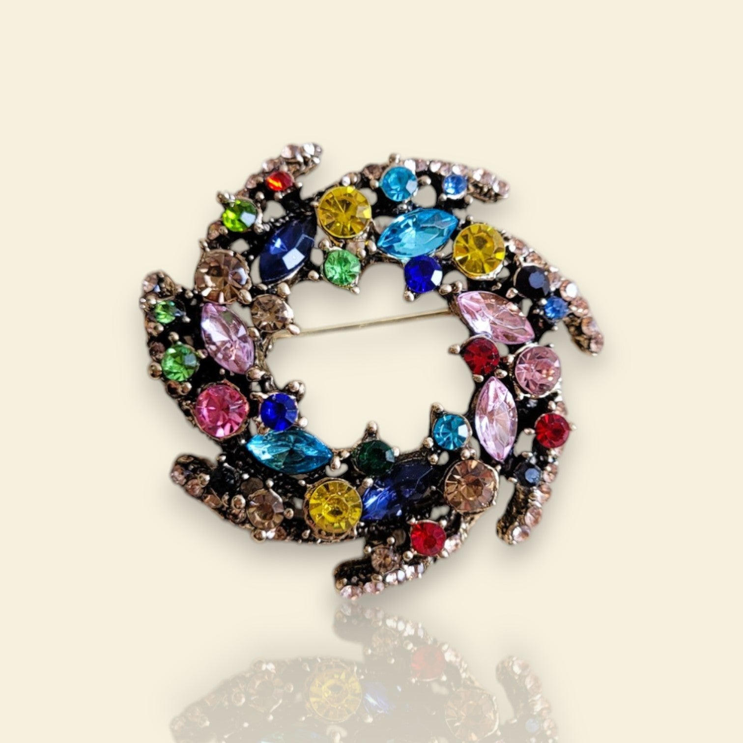 broche dorée Vivella, un bijou moderne en forme de couronne de strass multicolores 