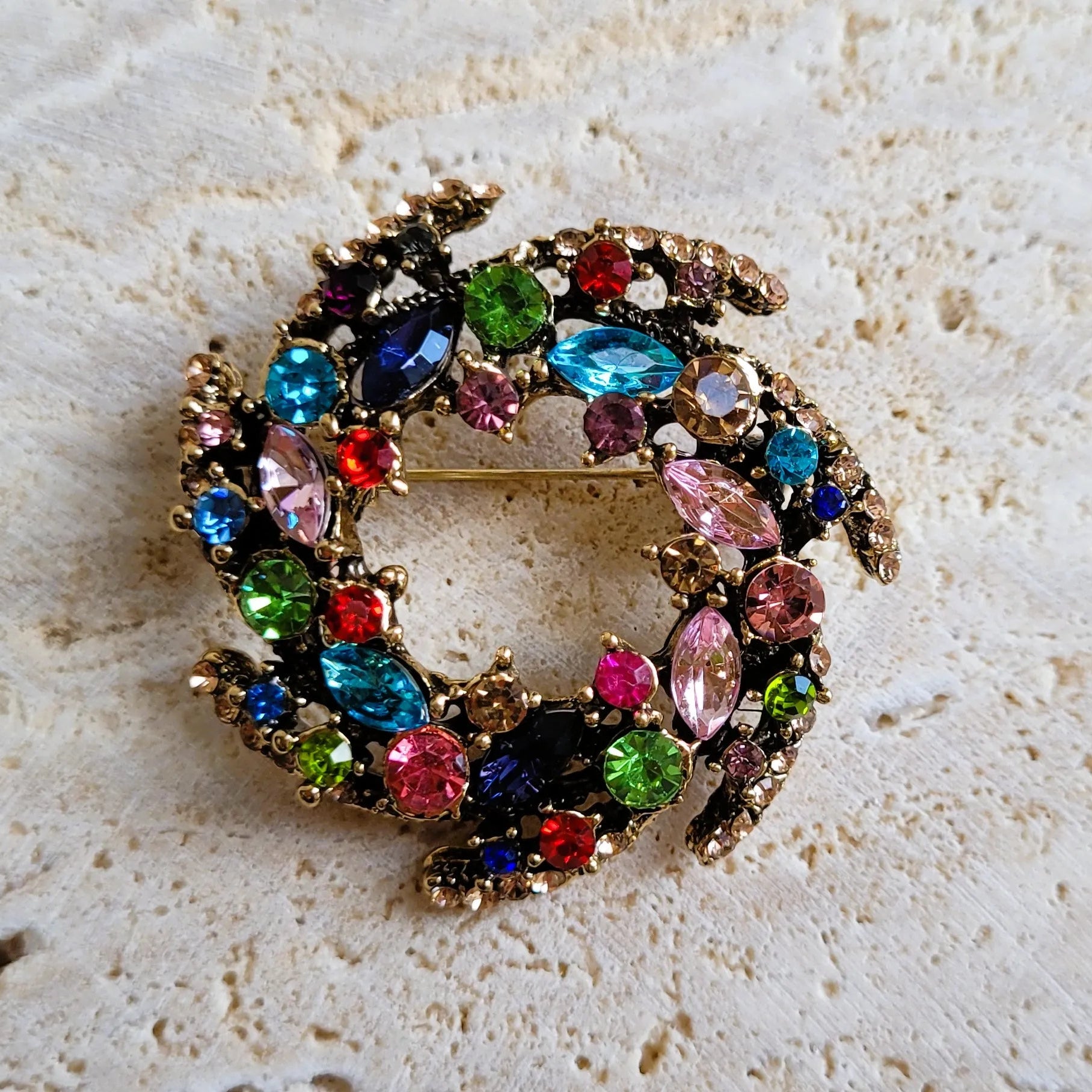 broche dorée Vivella, une broche design en forme de couronne de strass multicolores