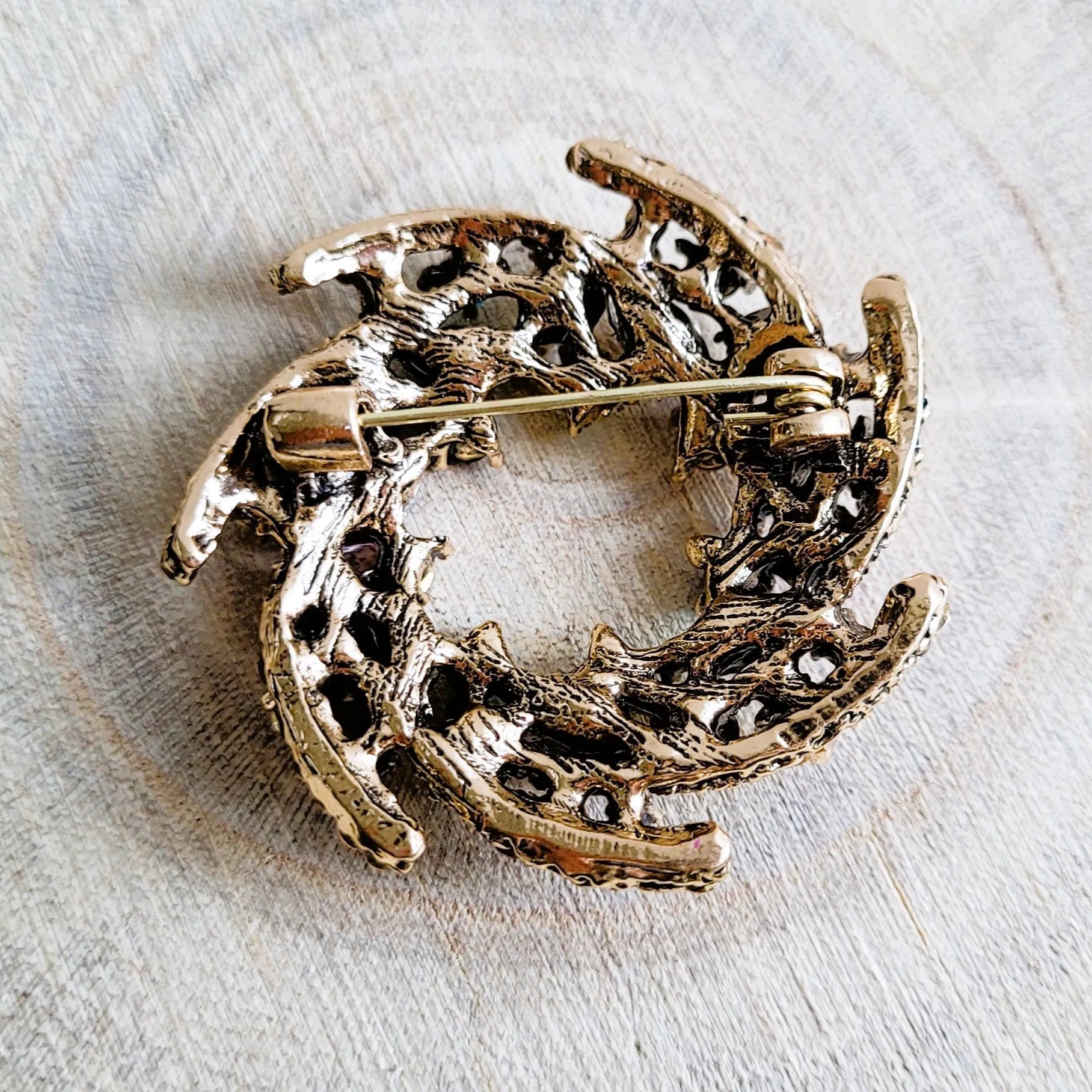 une broche dorée Vivella de luxe en couronne de strass multicolores