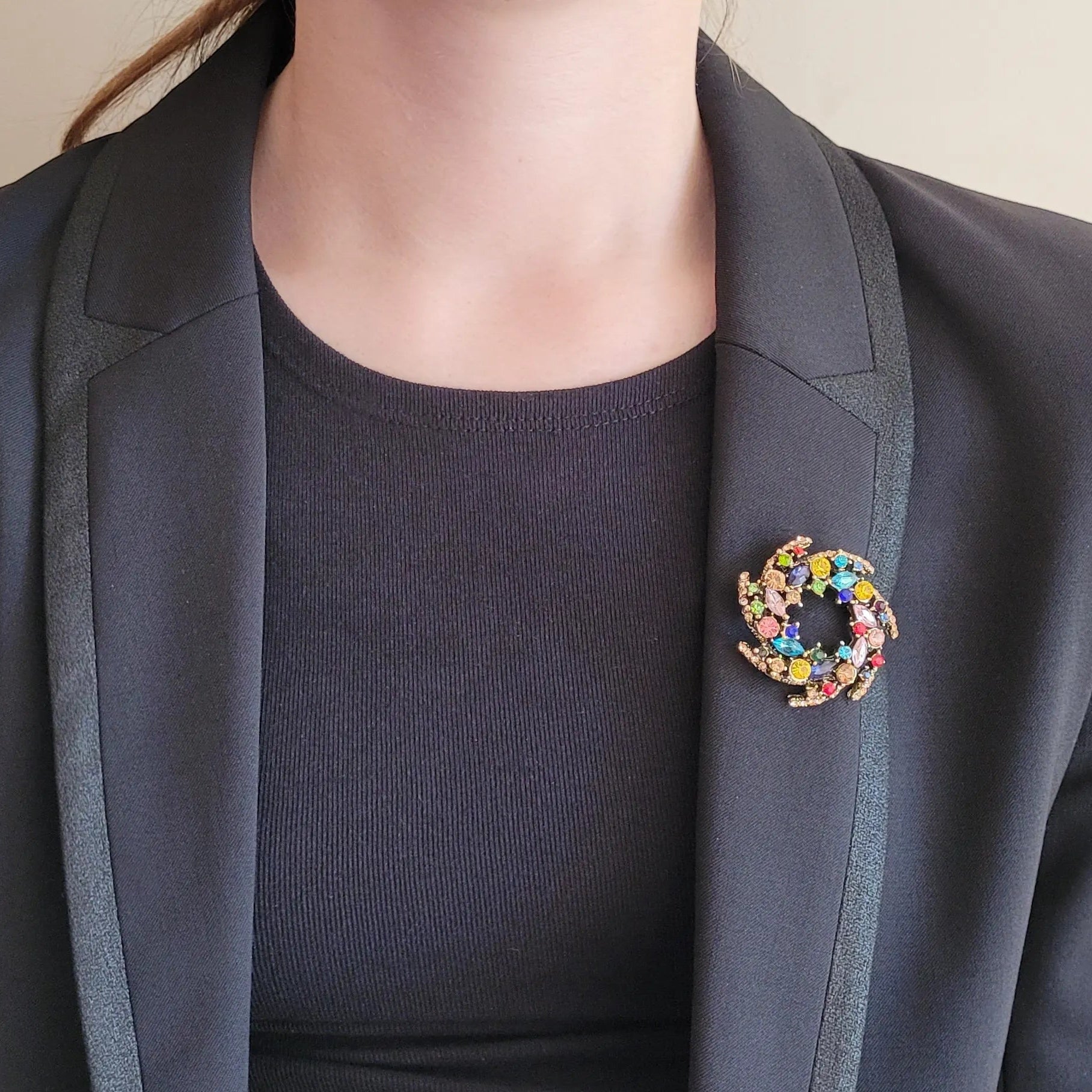 broche dorée Vivella, une broche en forme de couronne de strass multicolores pour vêtement de femme