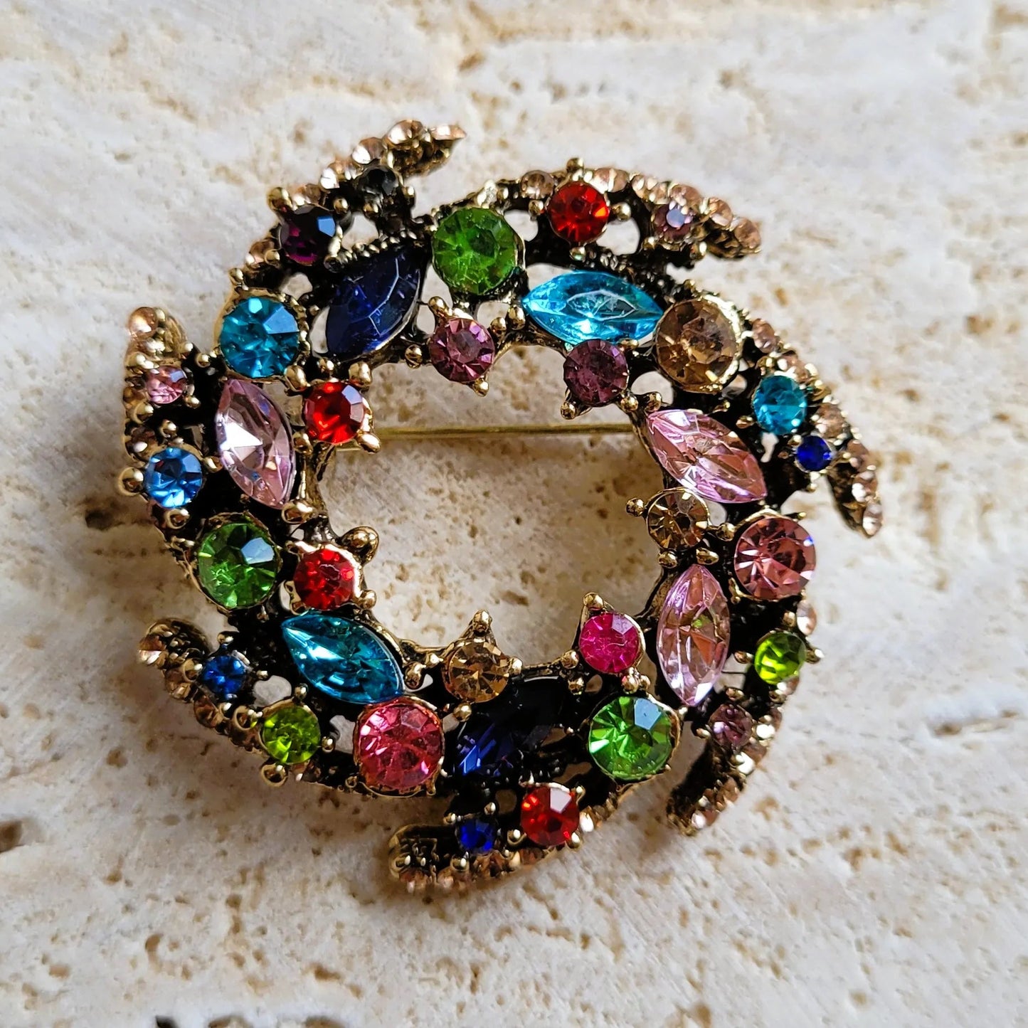 broche dorée Vivella, une broche design en forme de couronne de strass multicolores