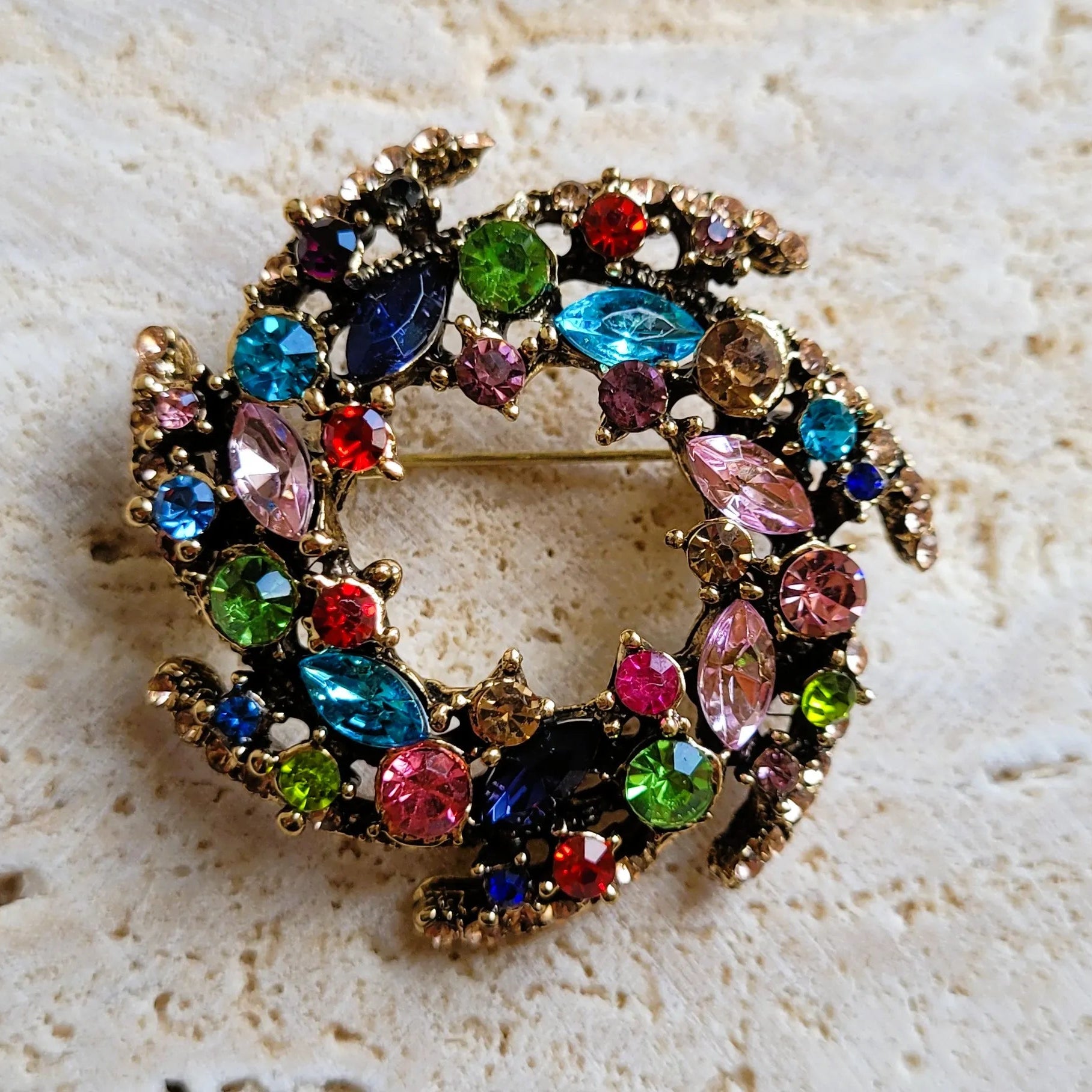 broche dorée Vivella, une broche design en forme de couronne de strass multicolores