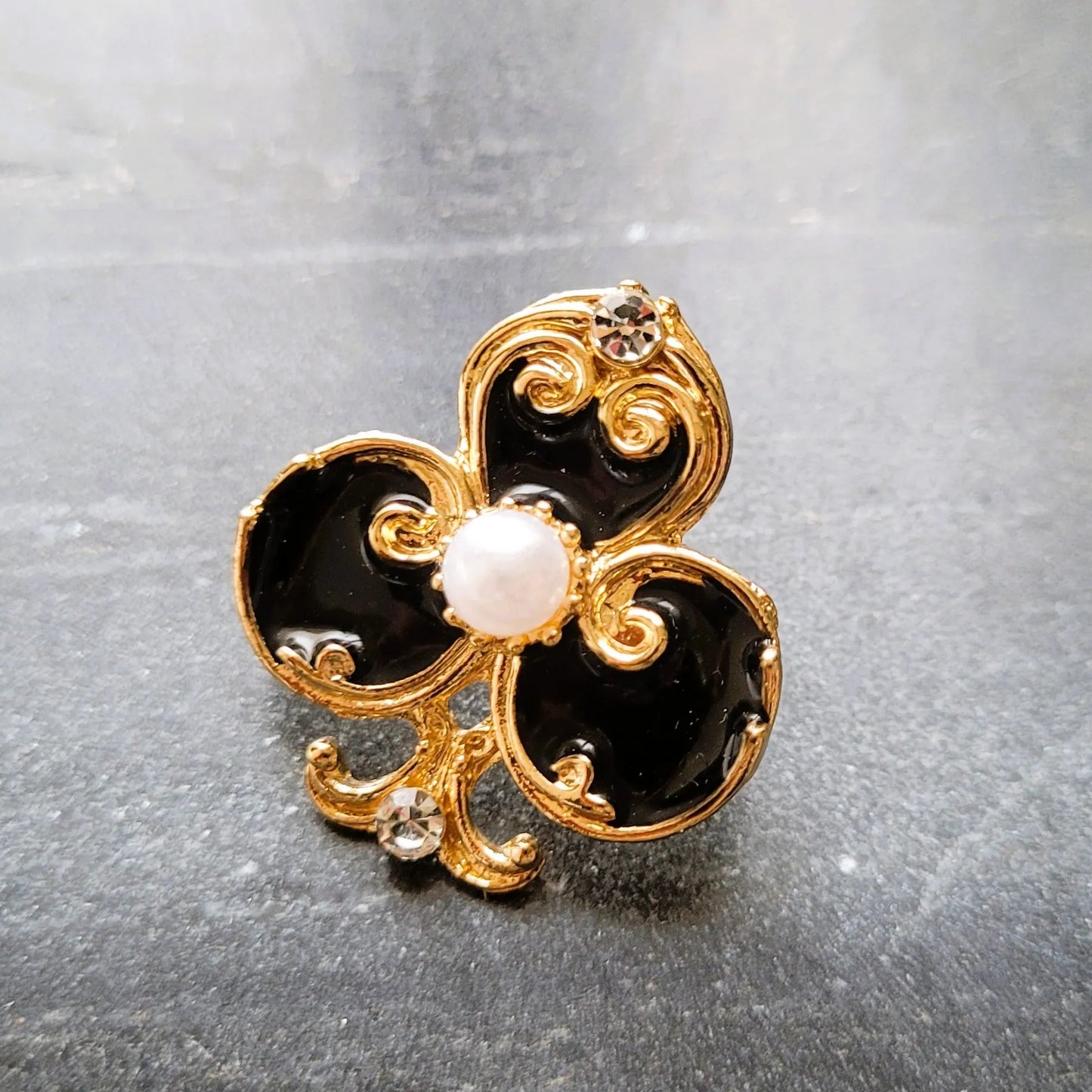 broche pour vêtement de femme Fortuna, un bijou en forme d’as de trèfle doré et noir