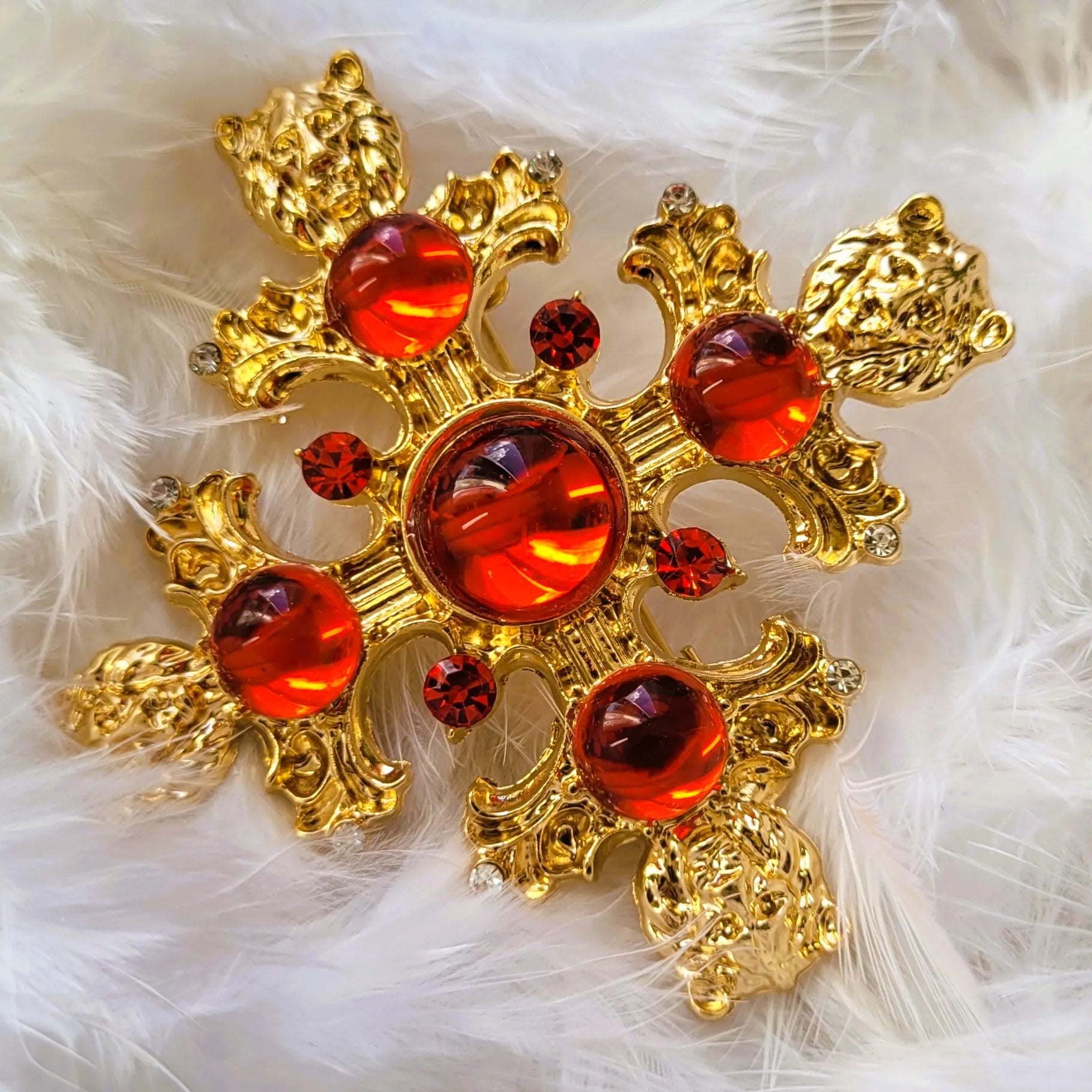 broche pour vêtement de femme Gloria, une broche fantaisie dorée et sculptée de têtes de lions