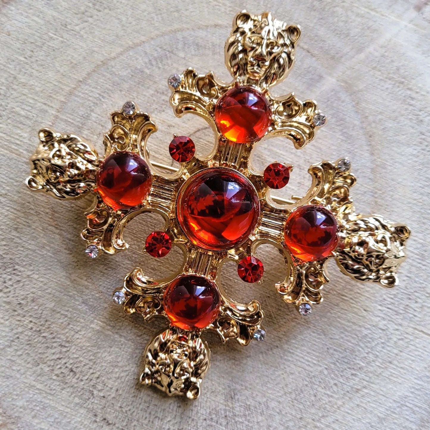 broche pour vêtement de femme Gloria, une broche luxueuse dorée et sculptée de têtes de lions