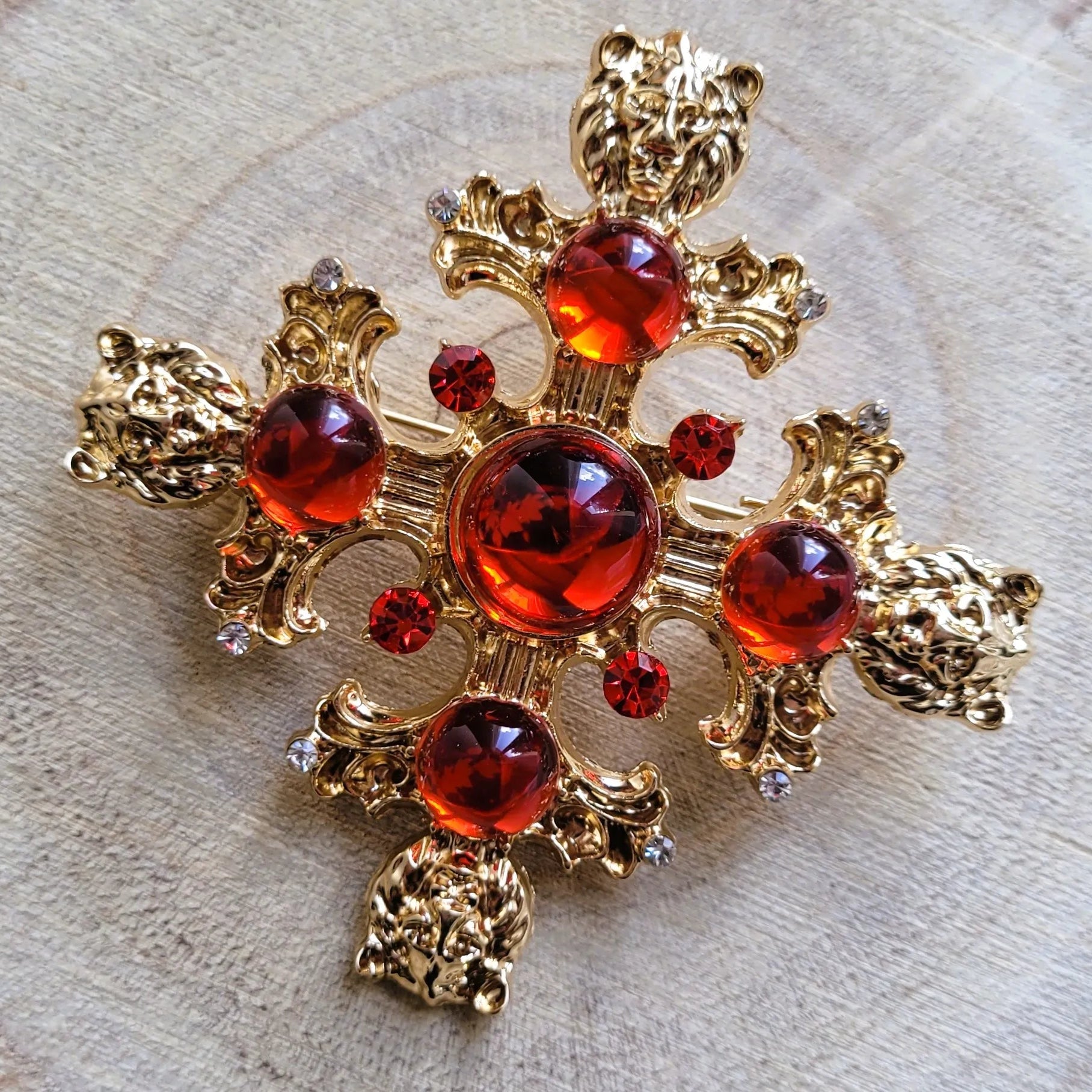 broche pour vêtement de femme Gloria, une broche luxueuse dorée et sculptée de têtes de lions