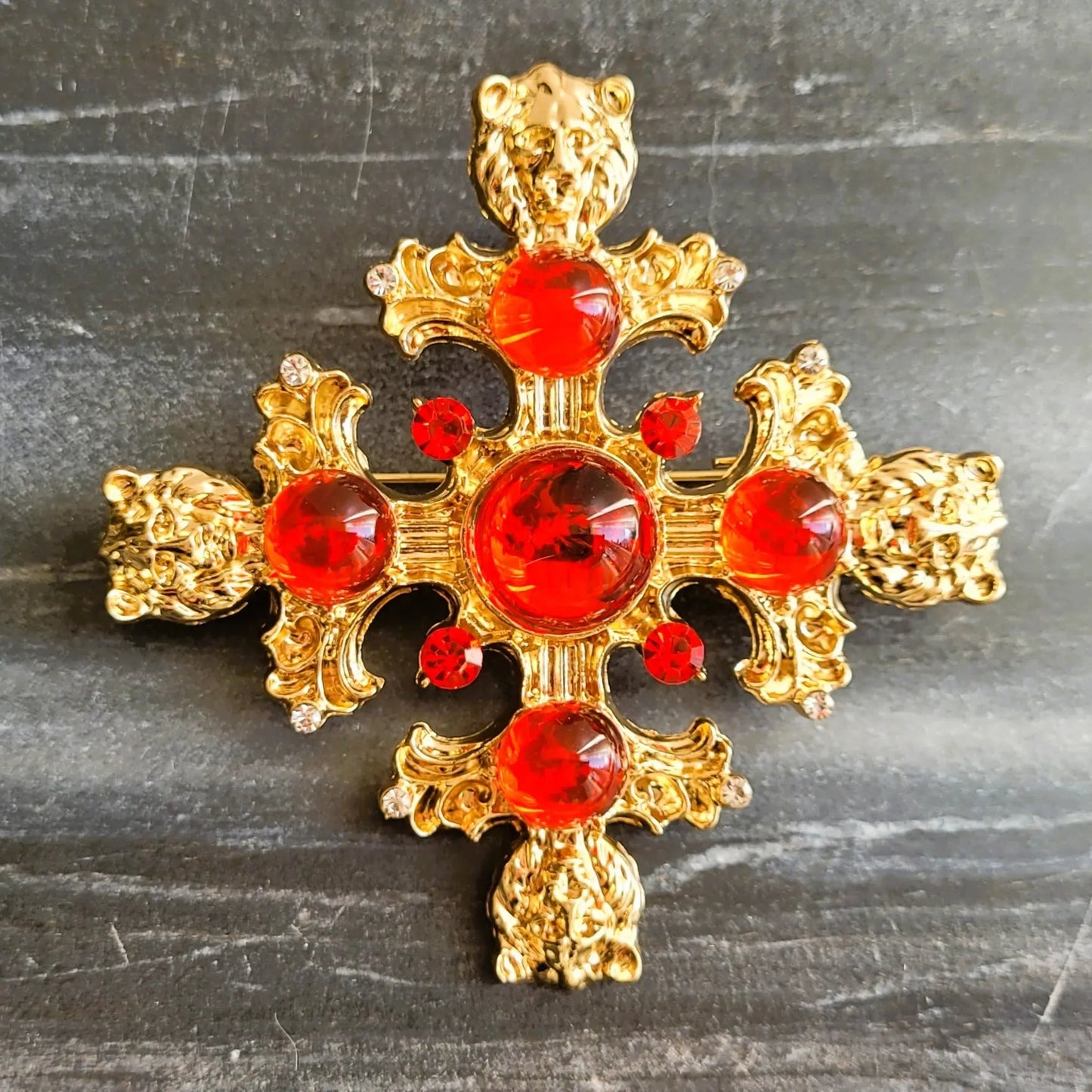 broche pour vêtement de femme Gloria, un bijou doré et sculpté de têtes de lions