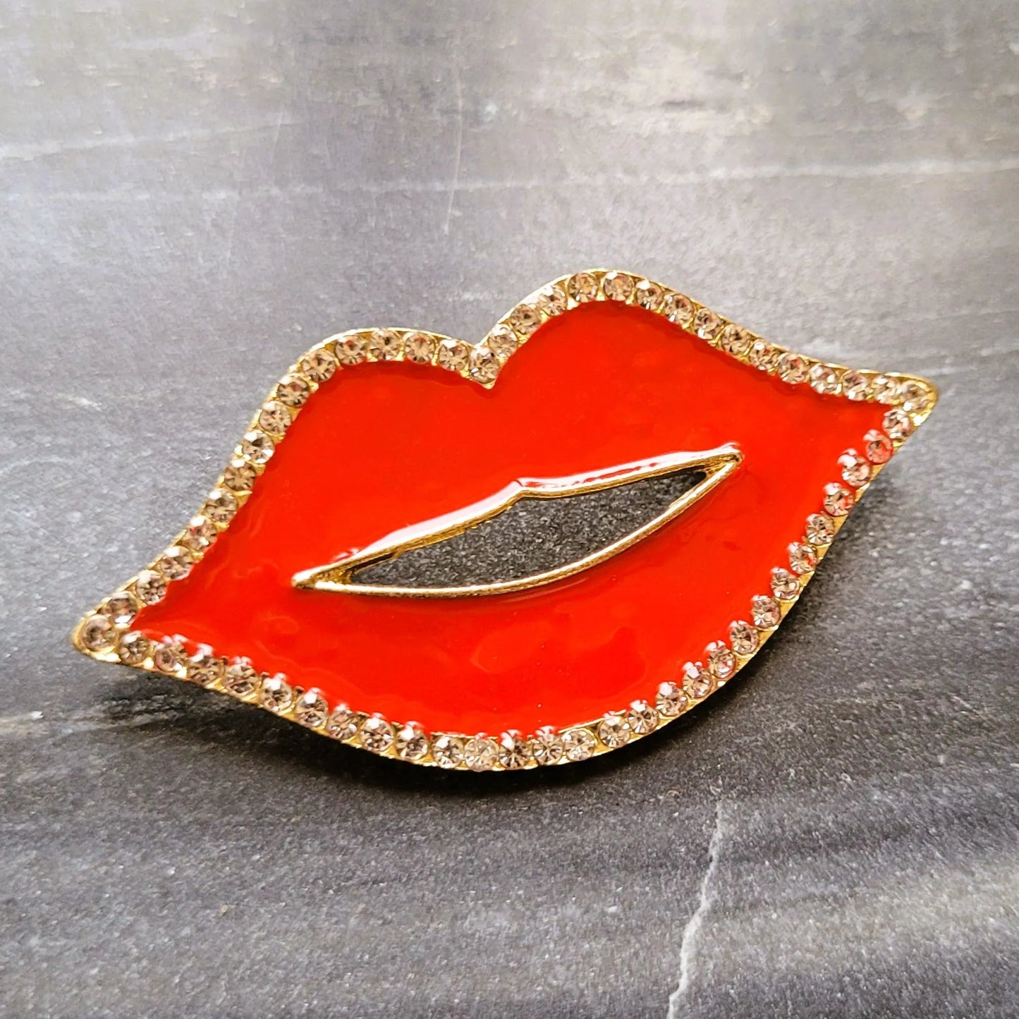 broche pour vêtement de femme Lipsy, un bijou en forme de bouche rouge avec des strass