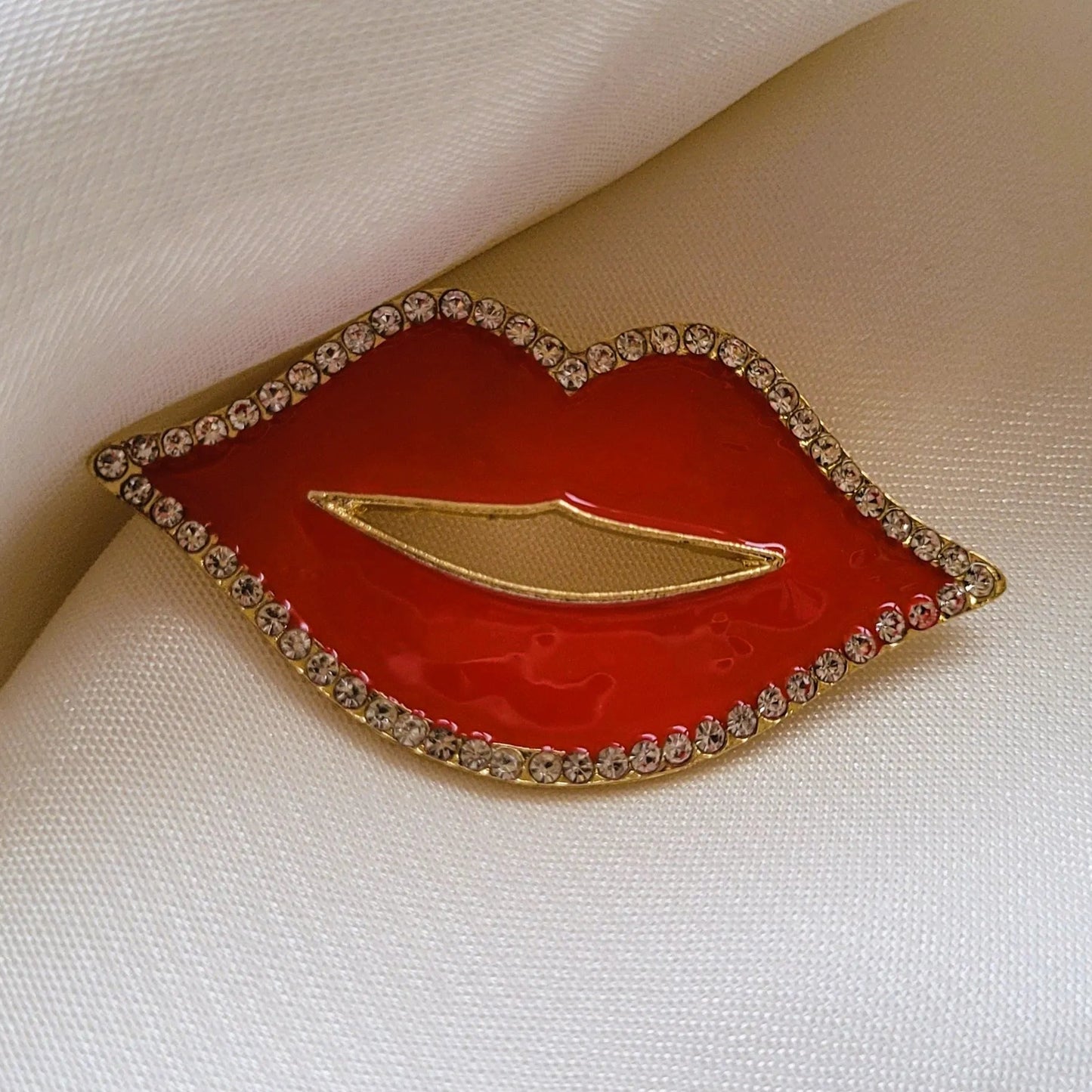 broche pour vêtement de femme Lipsy, un bijou en forme de bouche rouge avec des strass