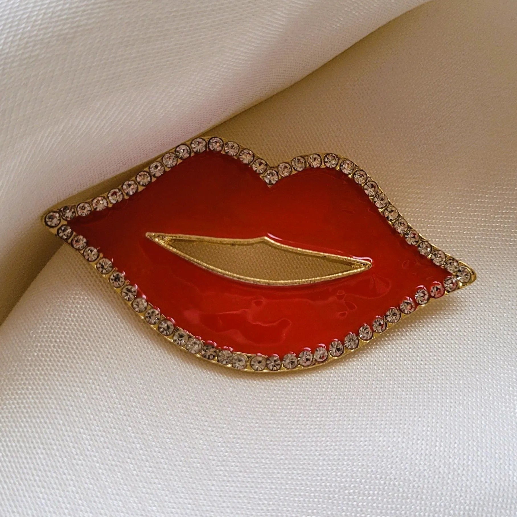 broche pour vêtement de femme Lipsy, un bijou en forme de bouche rouge avec des strass