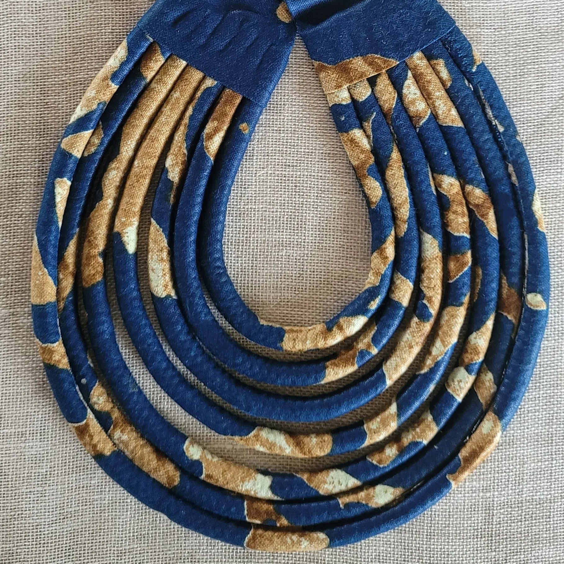 collier en tissu Aïda, un bijou africain traditionnel composé de sept rangs de cordons recouverts de tissu wax