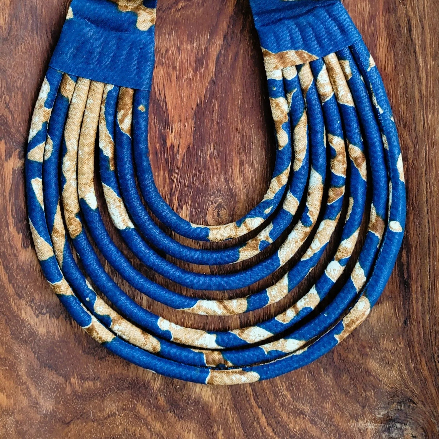 collier en tissu Aïda, un collier coloré composé de sept rangs de cordons recouverts de tissu wax