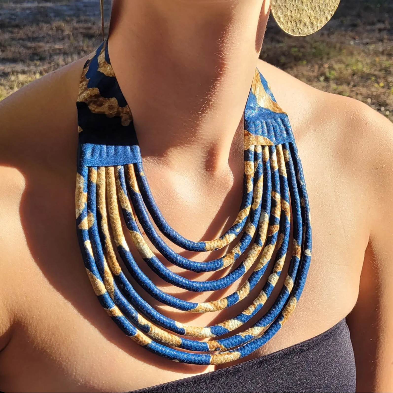 collier en tissu Aïda, un collier ethnique chic composé de sept rangs de cordons recouverts de tissu wax