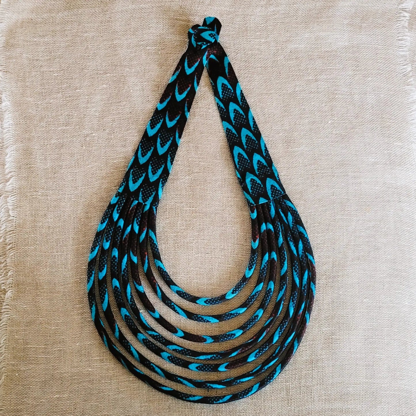 collier en tissu Awa, un bijou africain traditionnel composé de sept rangs de cordons recouverts de tissu wax